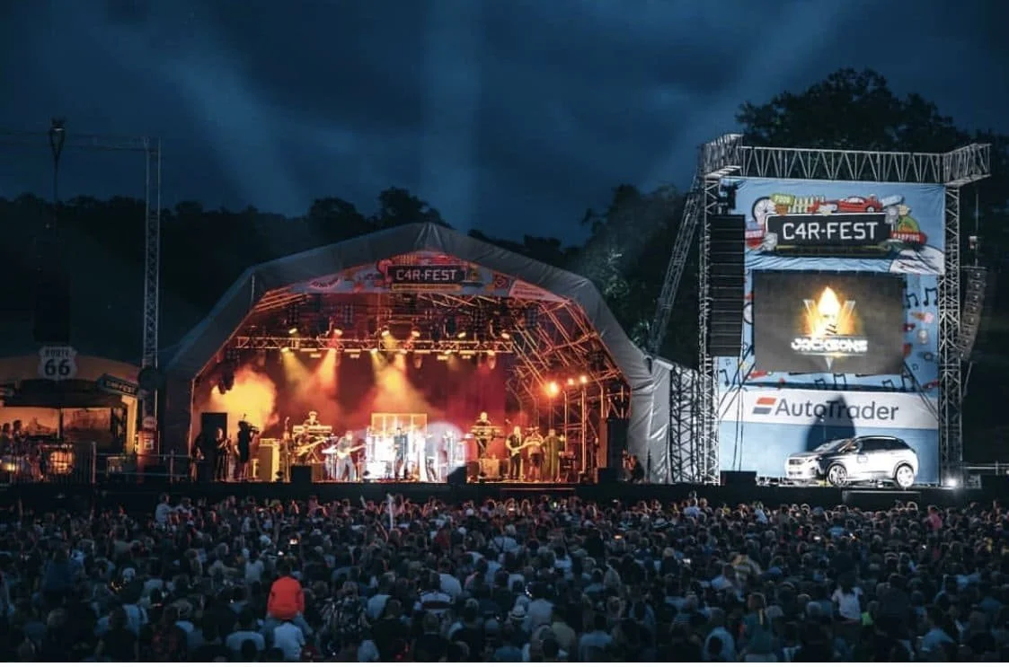 Crowd watching a live band on the main stage at Carfest at night