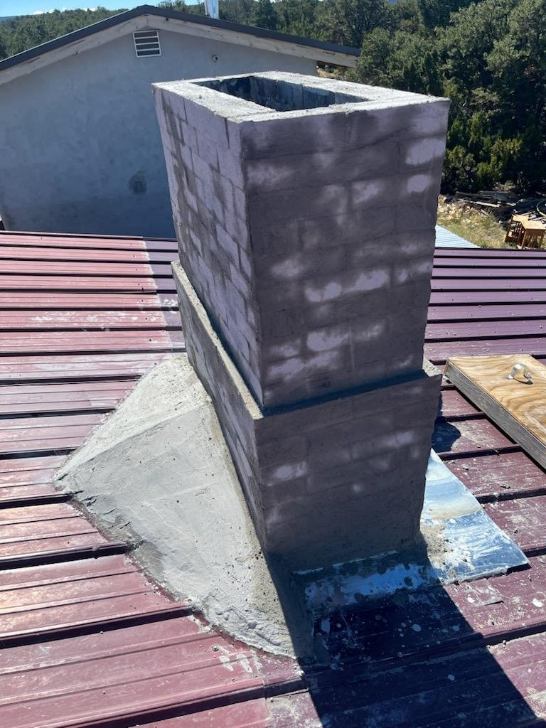 Chimney cricket in progress. We built a plywood armature and skirted the chimney with sheet metal. The plywood armature was covered with a concrete mix using as little water as possible.