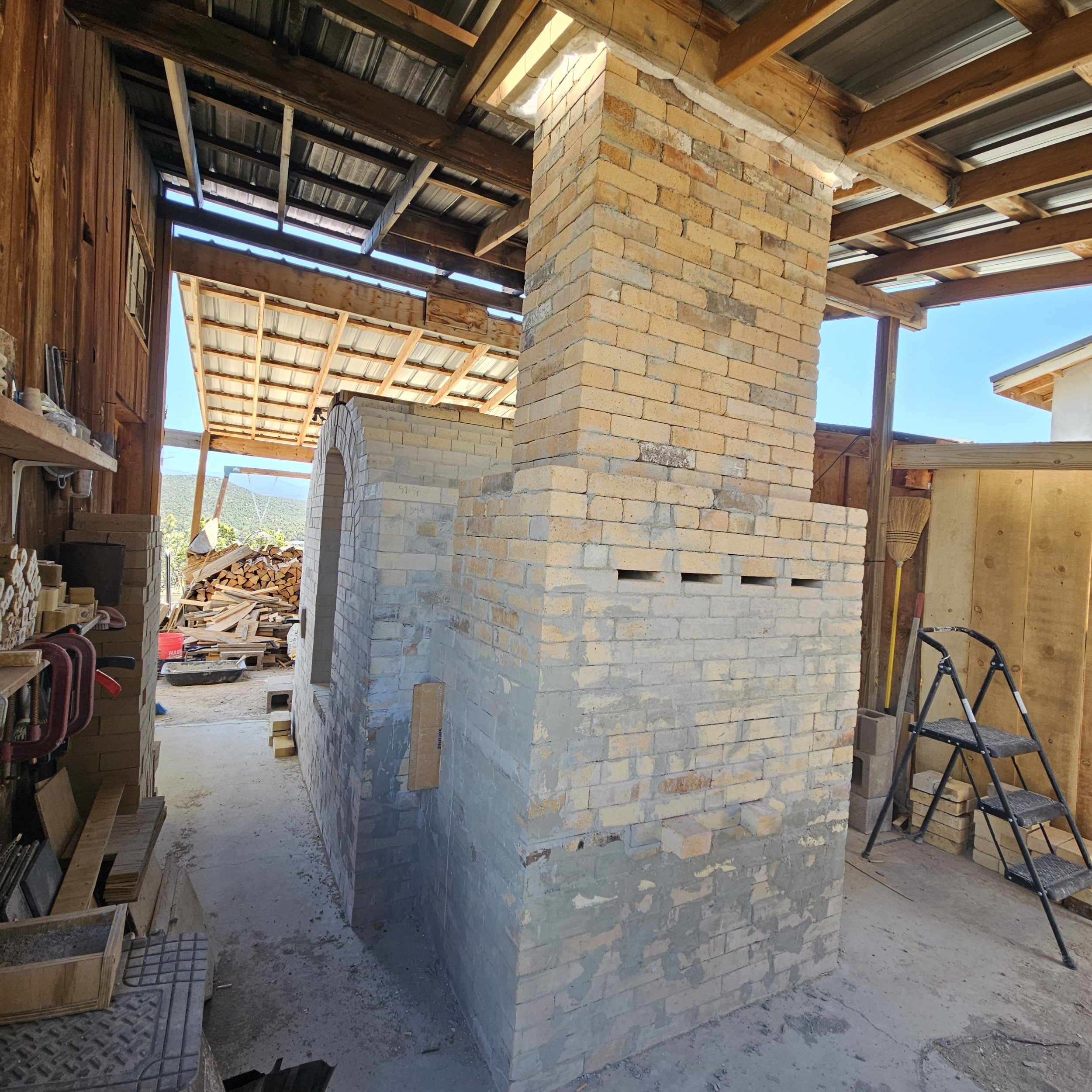 Chimney work continues after installing a kaowool layer on all sides of the header using bailing wire.