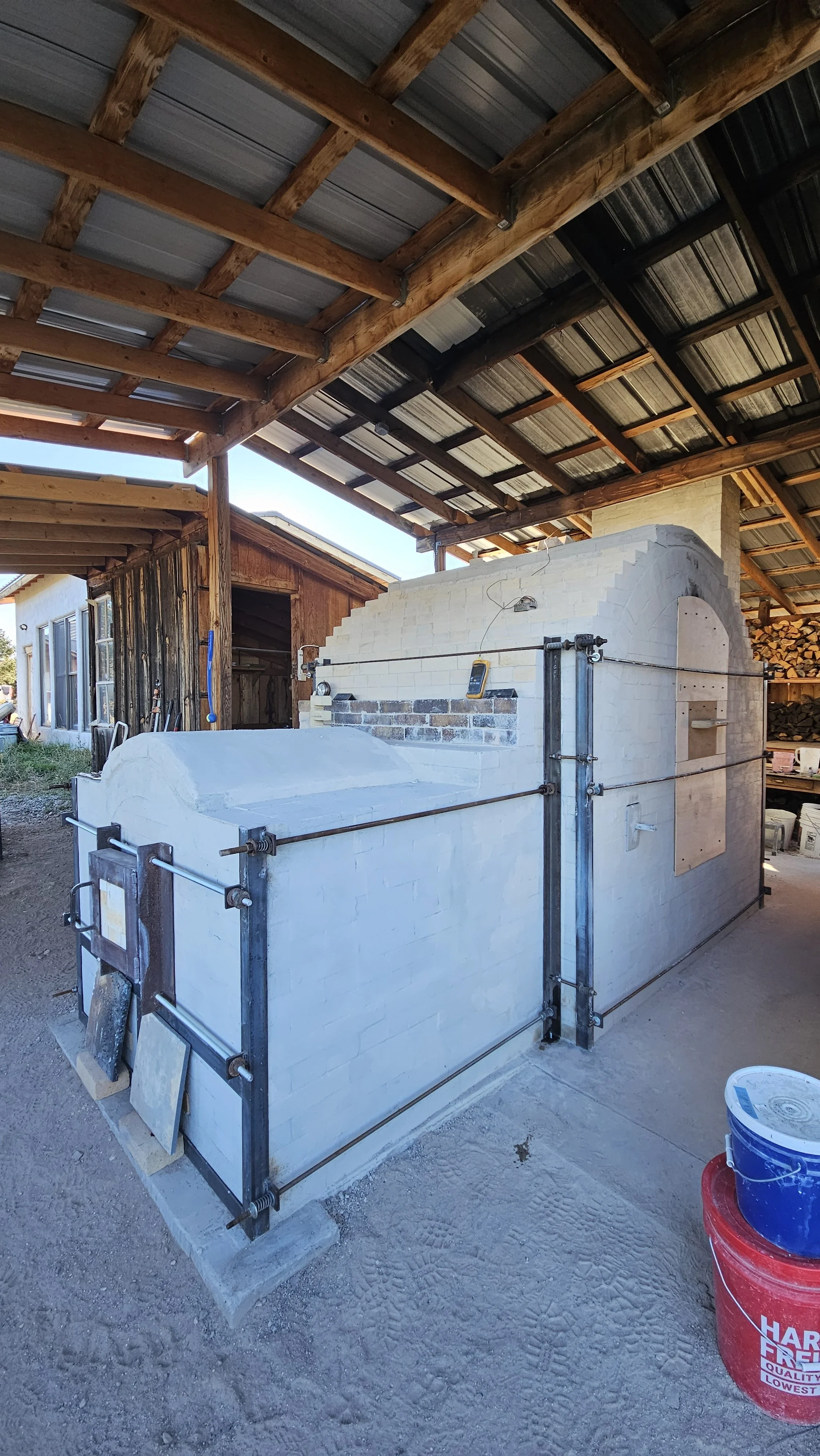 The kiln with the stoke port door on a hinge (this was the same one I used on my first kiln) and angle iron connected with threaded rod. Tori and I cut the tabs off the angle iron from the previous kiln and repositioned them for this new kiln. Petro 