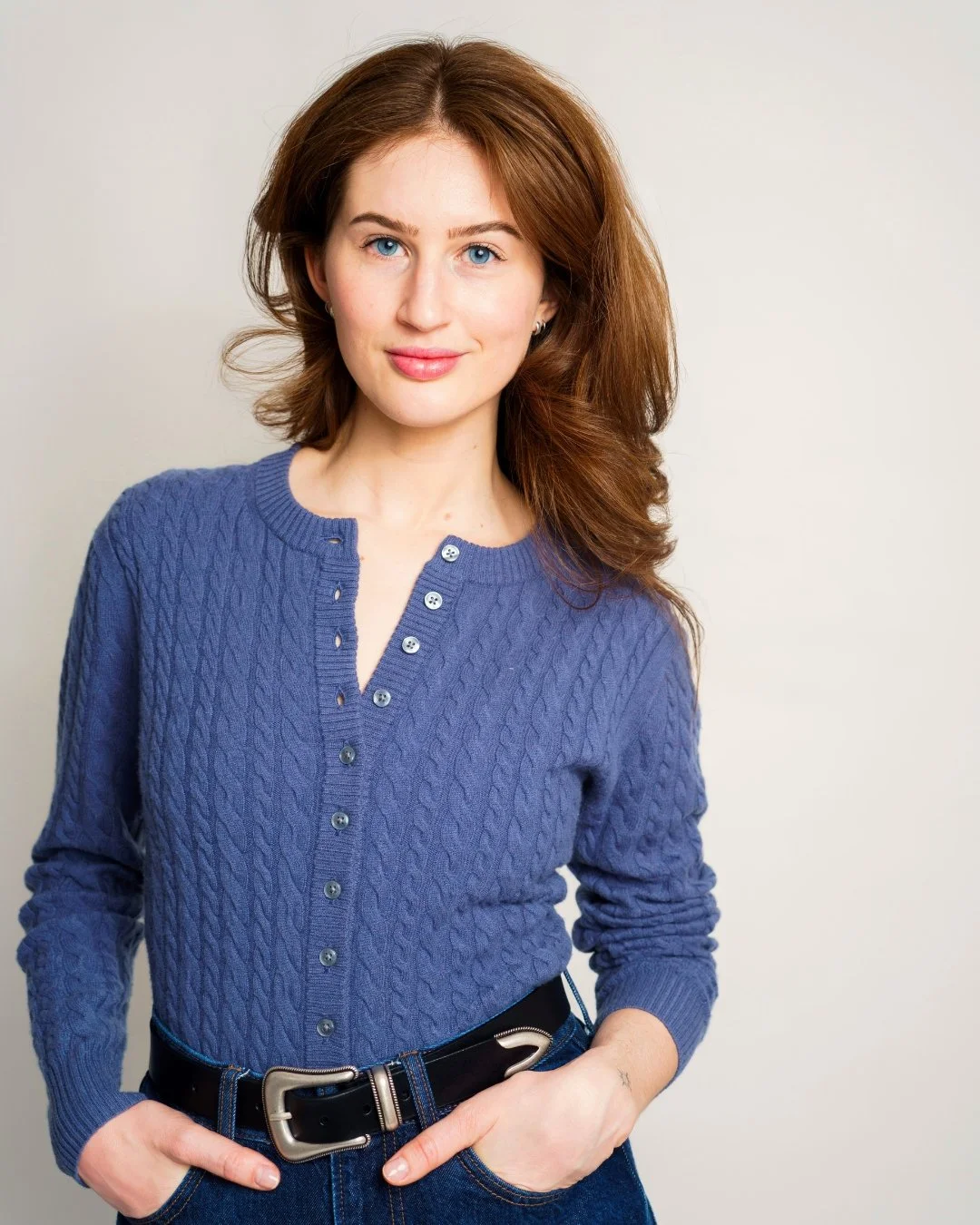 Magdalena, Esthetician and founder of SKINHAMPTON, smiling in a blue cardigan.