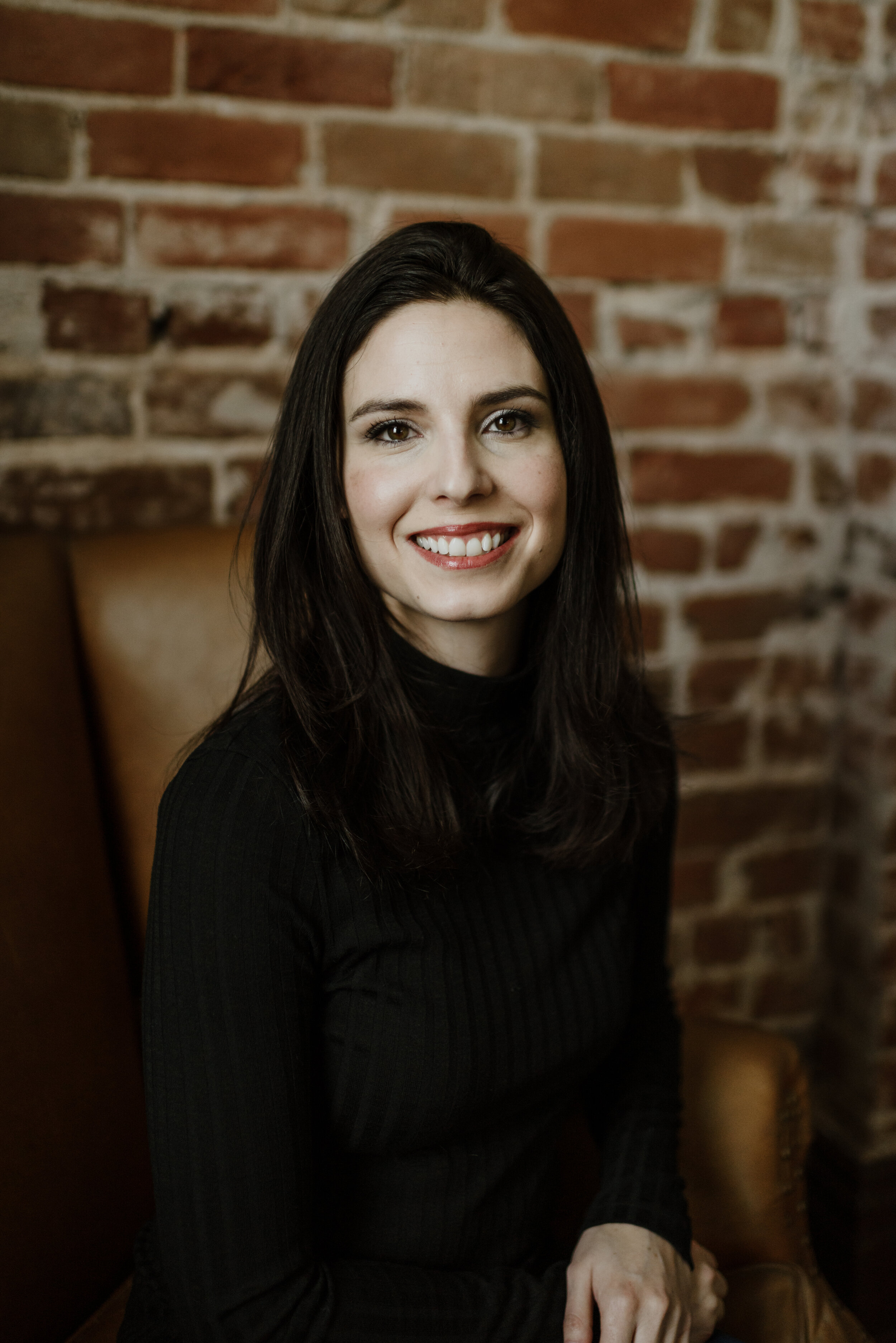 jodee-kane-sitting-in-front-of-brick-wall.jpg