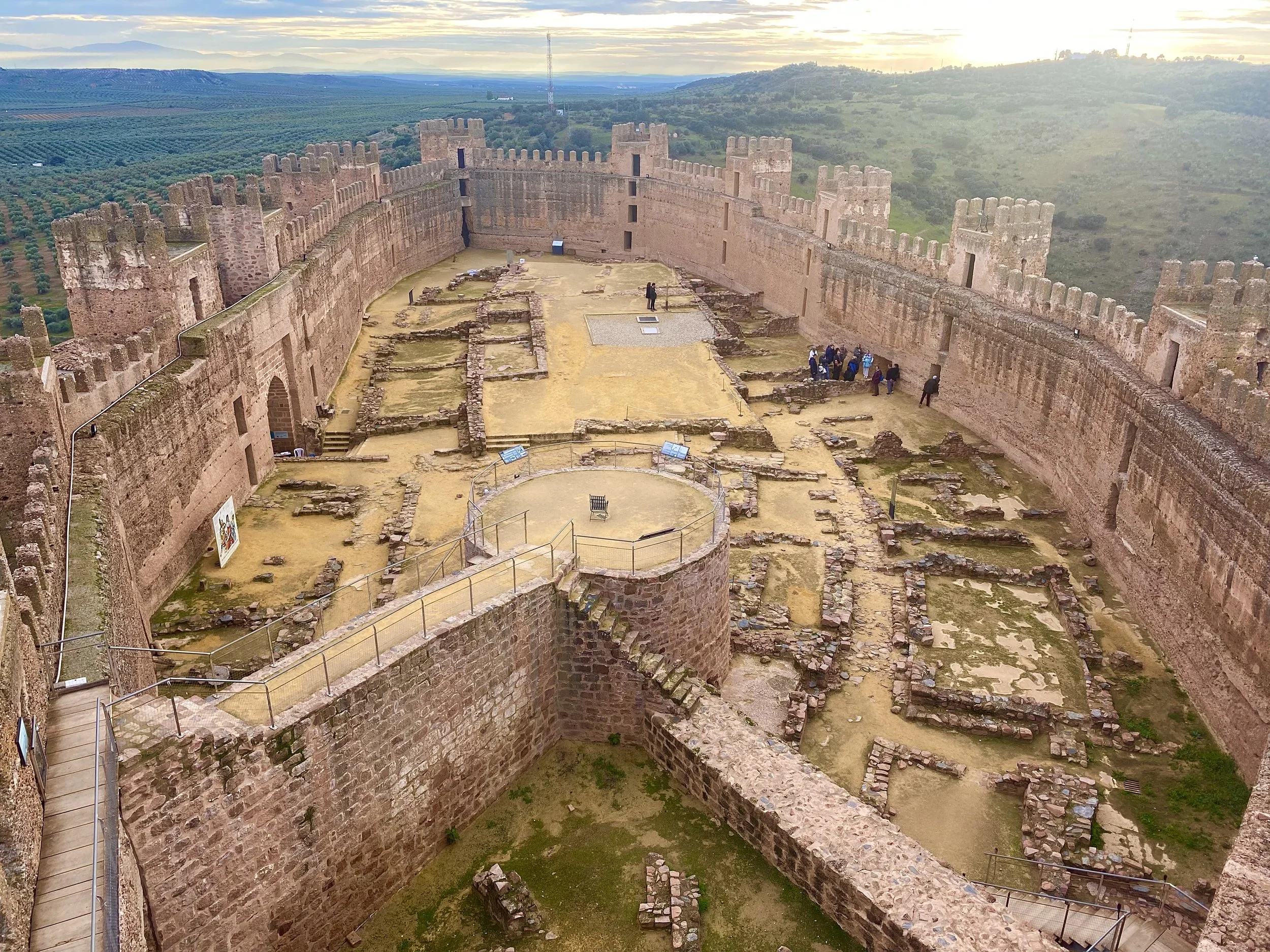 Scenic view of the medieval castle ruins in Baños de Encina, Spain, highlighting its historic stone architecture and surroundings.