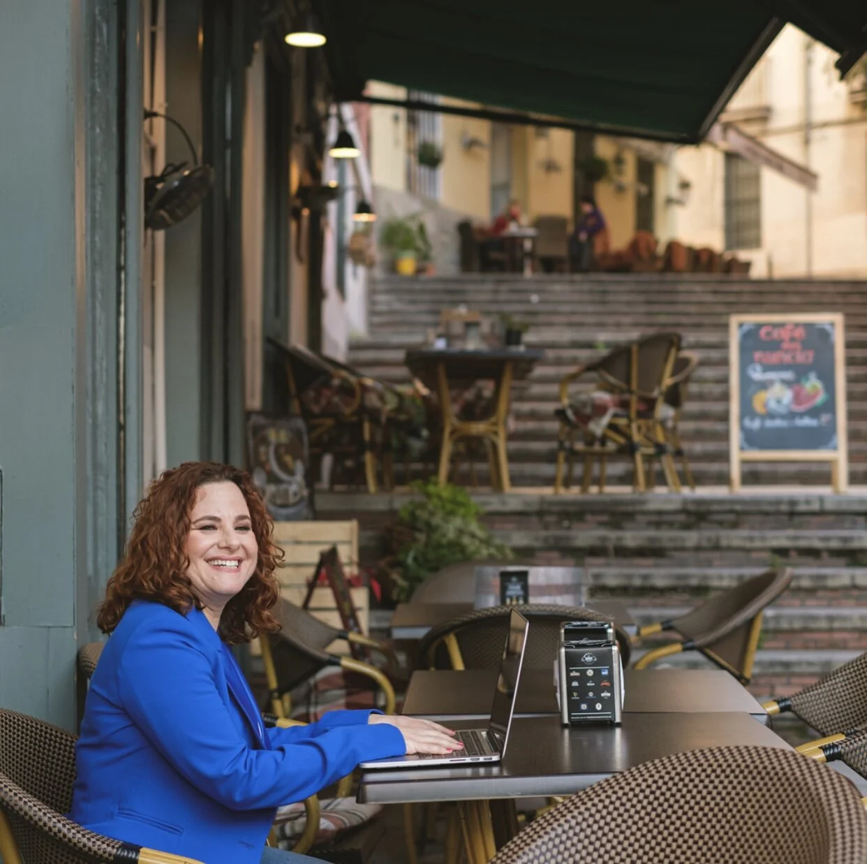 Karen Rosenblum, engaged with her laptop, surrounded by a warm and inviting atmosphere.