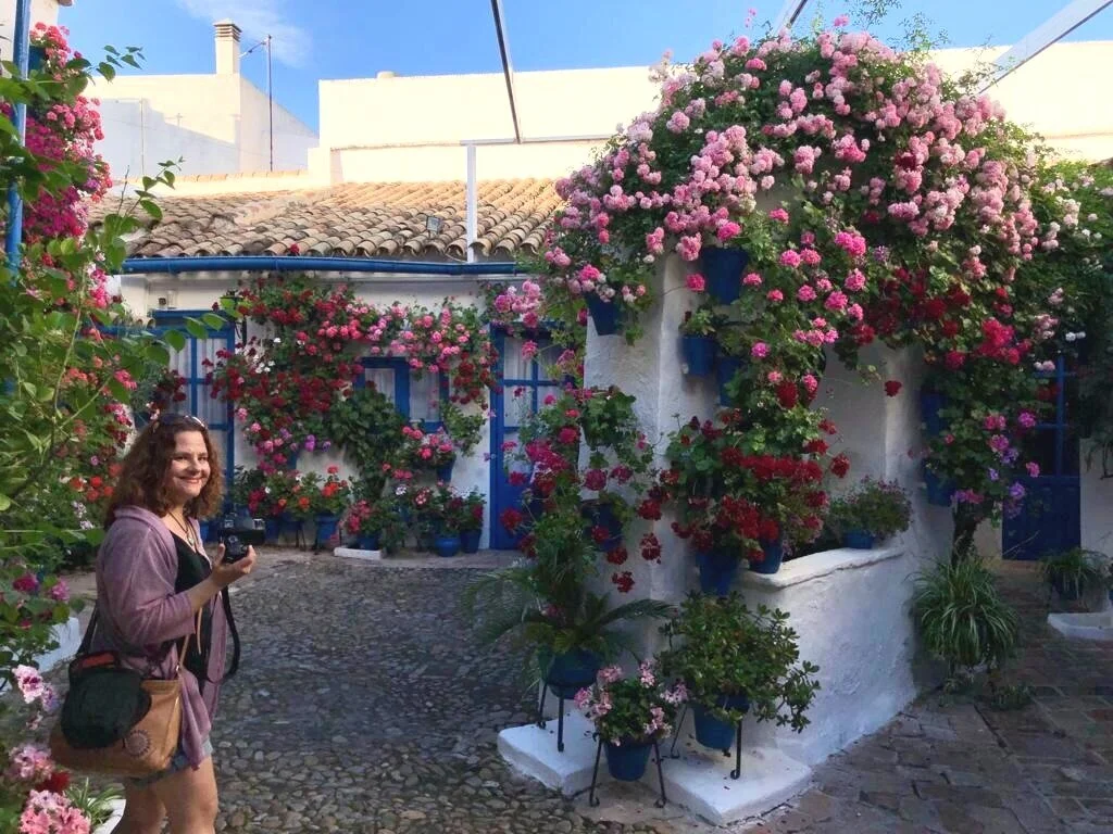 Karen, smiling, holding a camera in fiesta de los patios in Cordoba