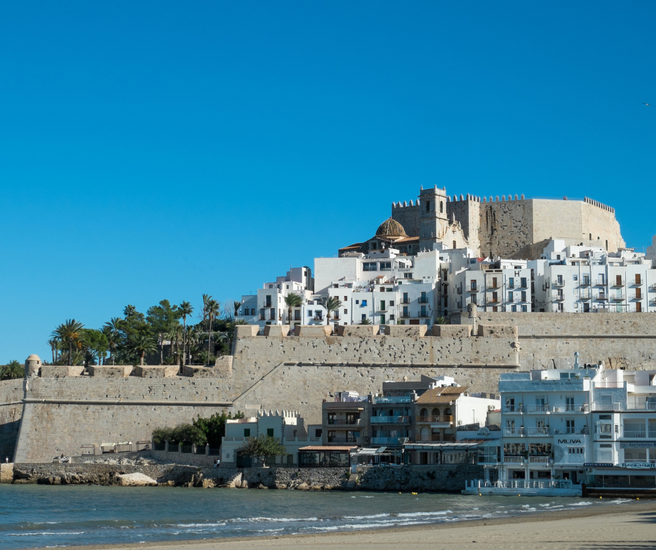 Scenic view of a white castle perched on a beach in Peñiscola, Spain, basking in the warm sunlight.