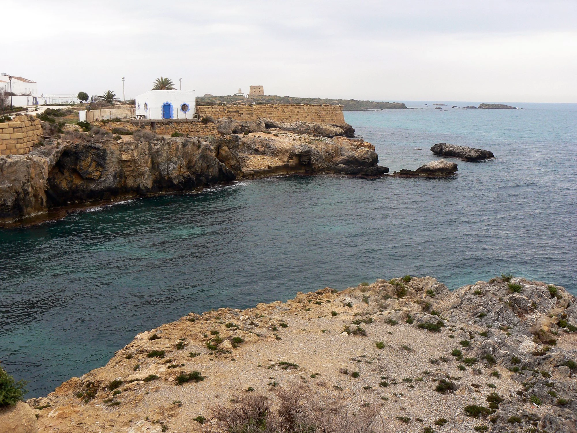 Stunning Tabarca island coast with vibrant blue waters and cliffs, capturing the essence of a less-traveled Alicante vibe.