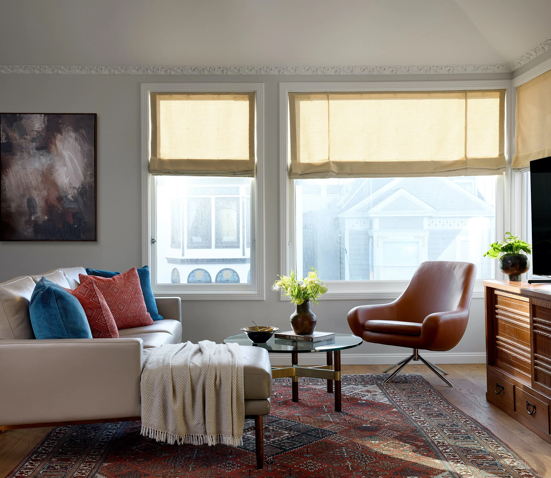 Miss Alice Designs - Midcentury modern luxury living room with a Joshagan rug, Design within reach furniture, Noomi chair, Raleigh sectional sofa, and Japanese custom tansu inspired media, round glass coffee table