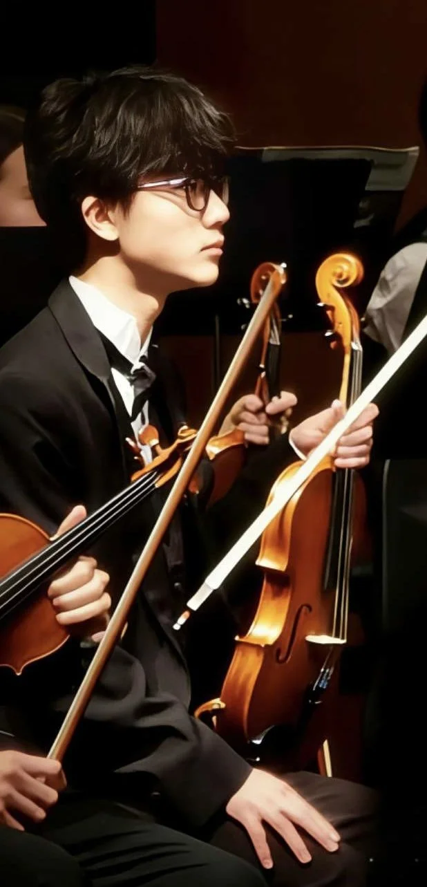 Person sitting facing to the side with black hair. wearing a black suit holding a violin.