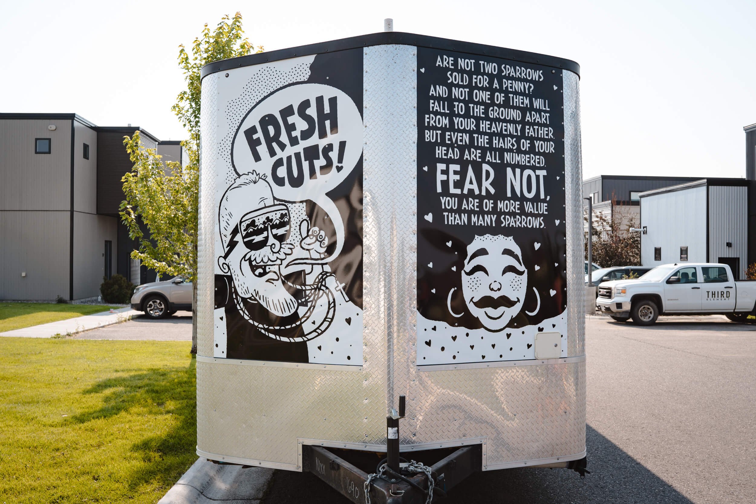 Front panel trailer graphics for Fresh Cuts in Bozeman, Montana, with illustrated characters and motivational scripture message reading ‘Fear Not’ in a bold, comic-style layout.