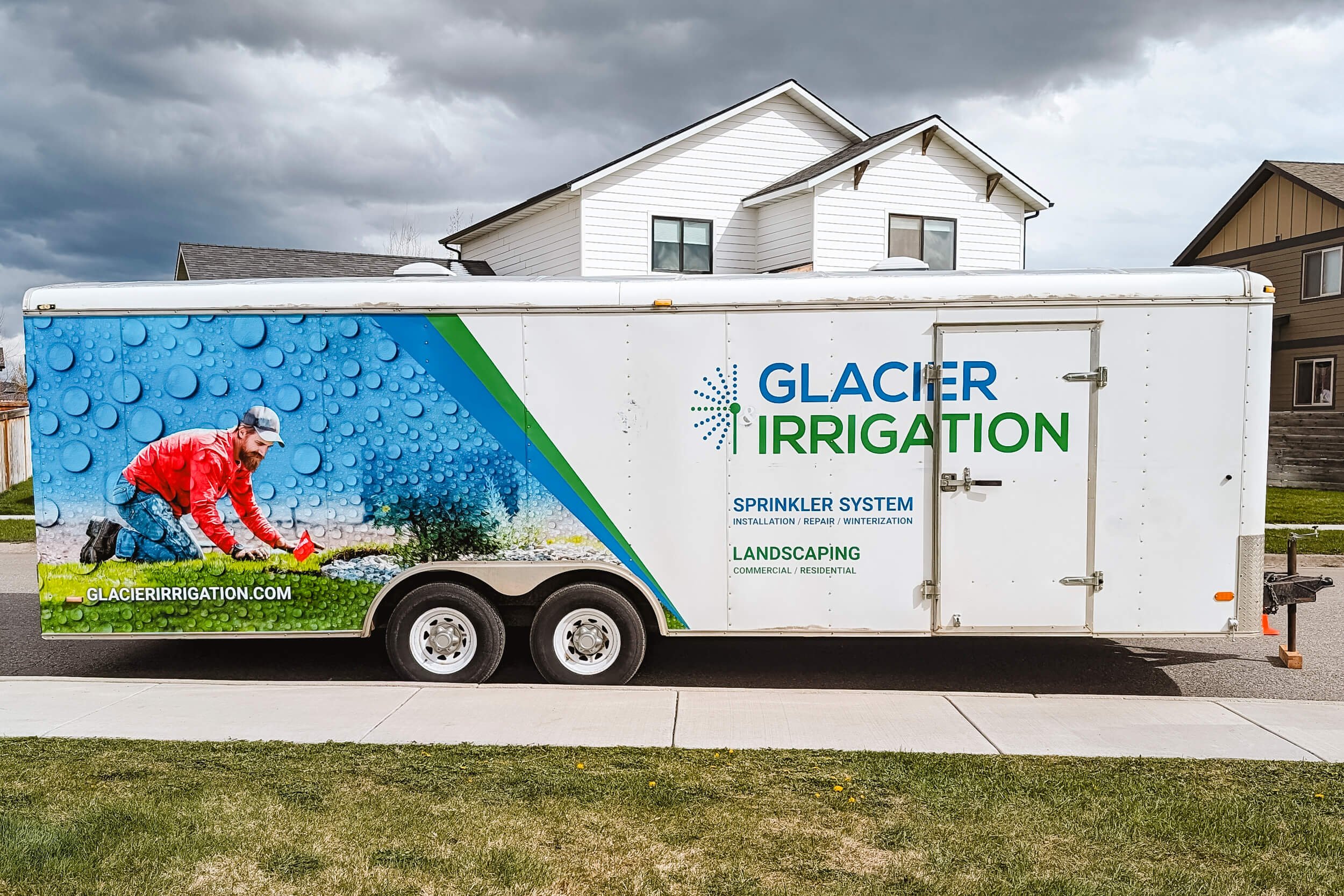 Side view of a large logo spot graphic and partial vinyl wrap for Glacier Irrigation. Features a photo of a man installing sprinkler systems