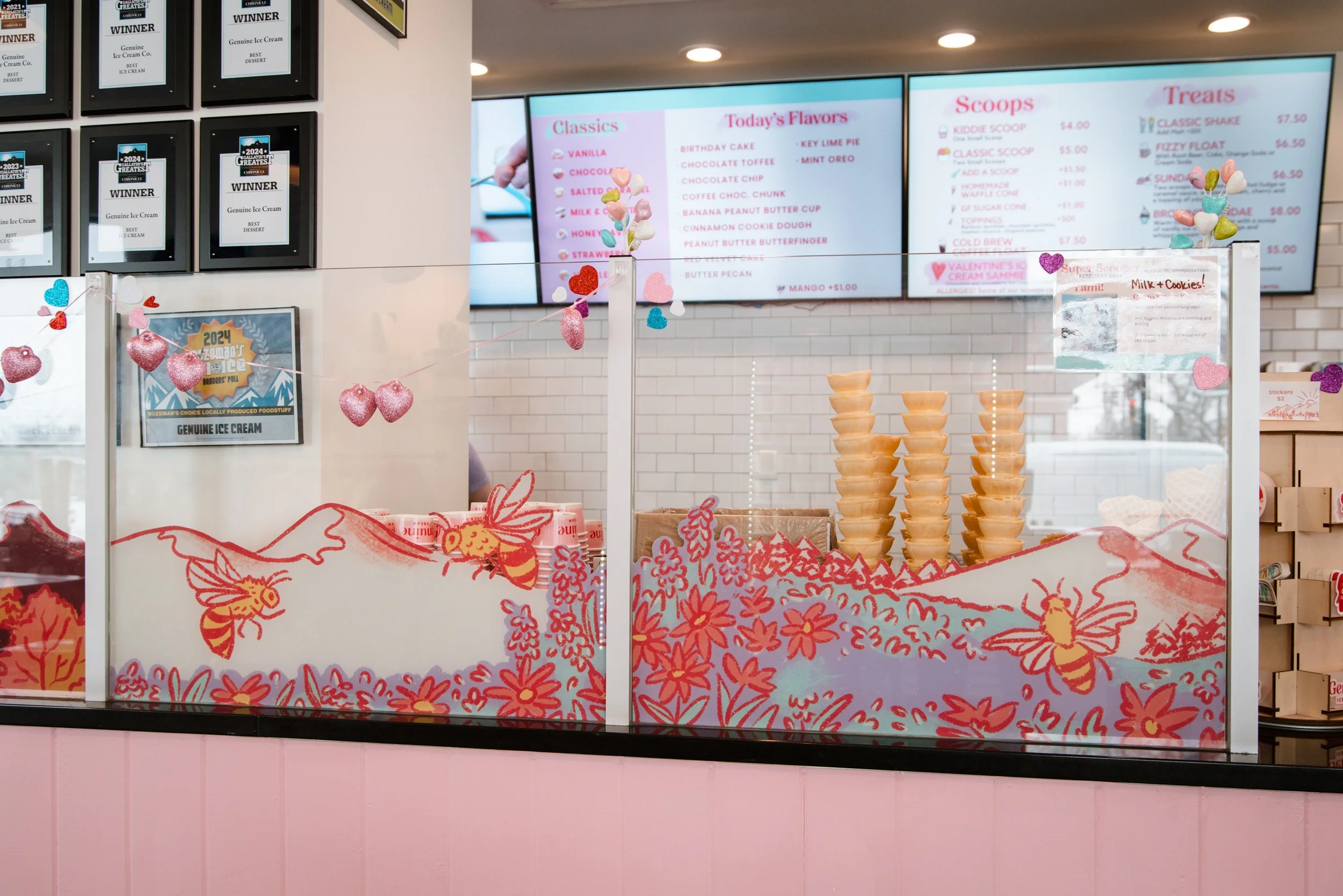 Interior window graphics on a protective divider at Genuine Ice Cream in Bozeman, MT, featuring a playful floral and bee-themed design.