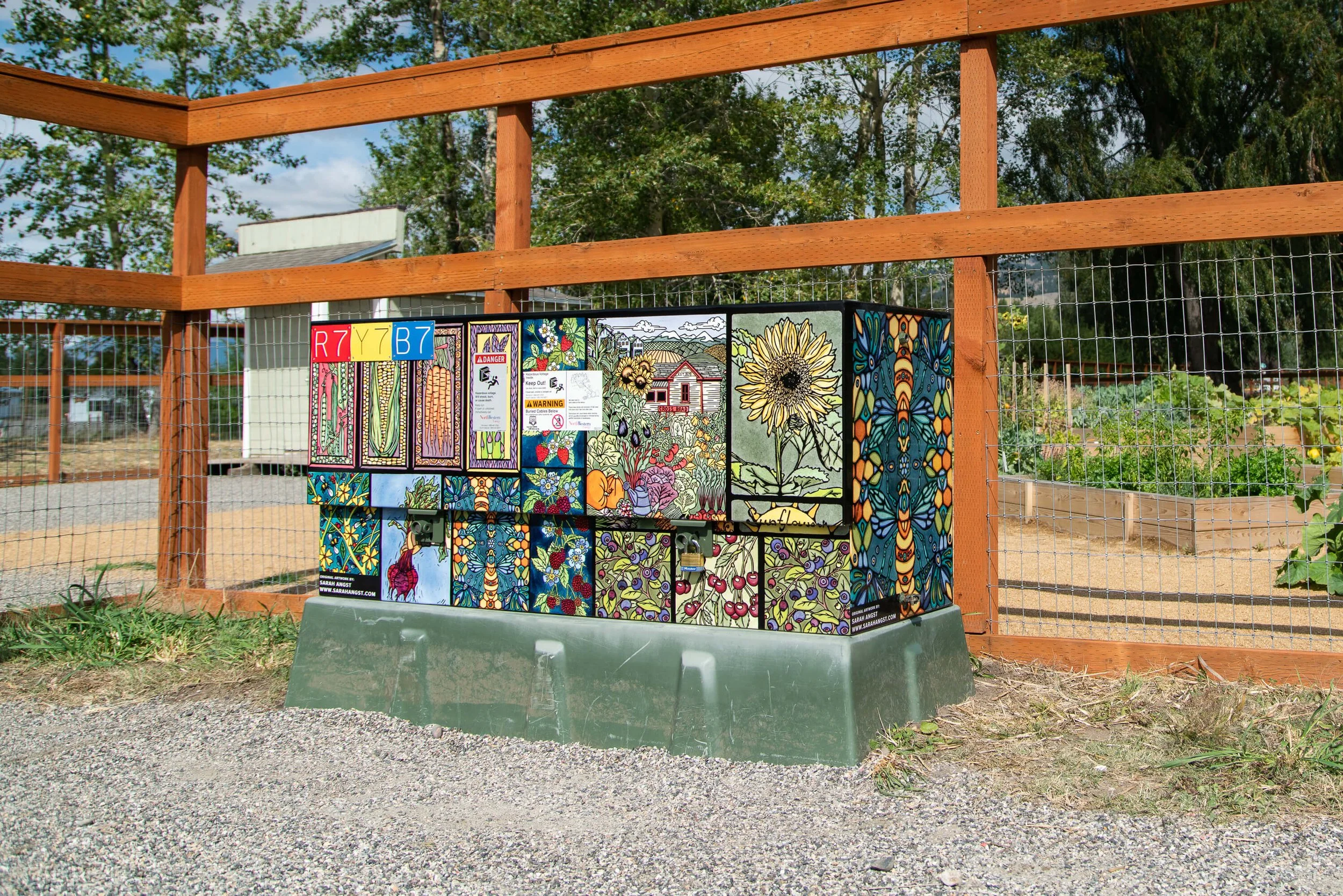 Custom vinyl wrap utility box covered in colorful artwork of flowers, vegetables, and farming imagery.