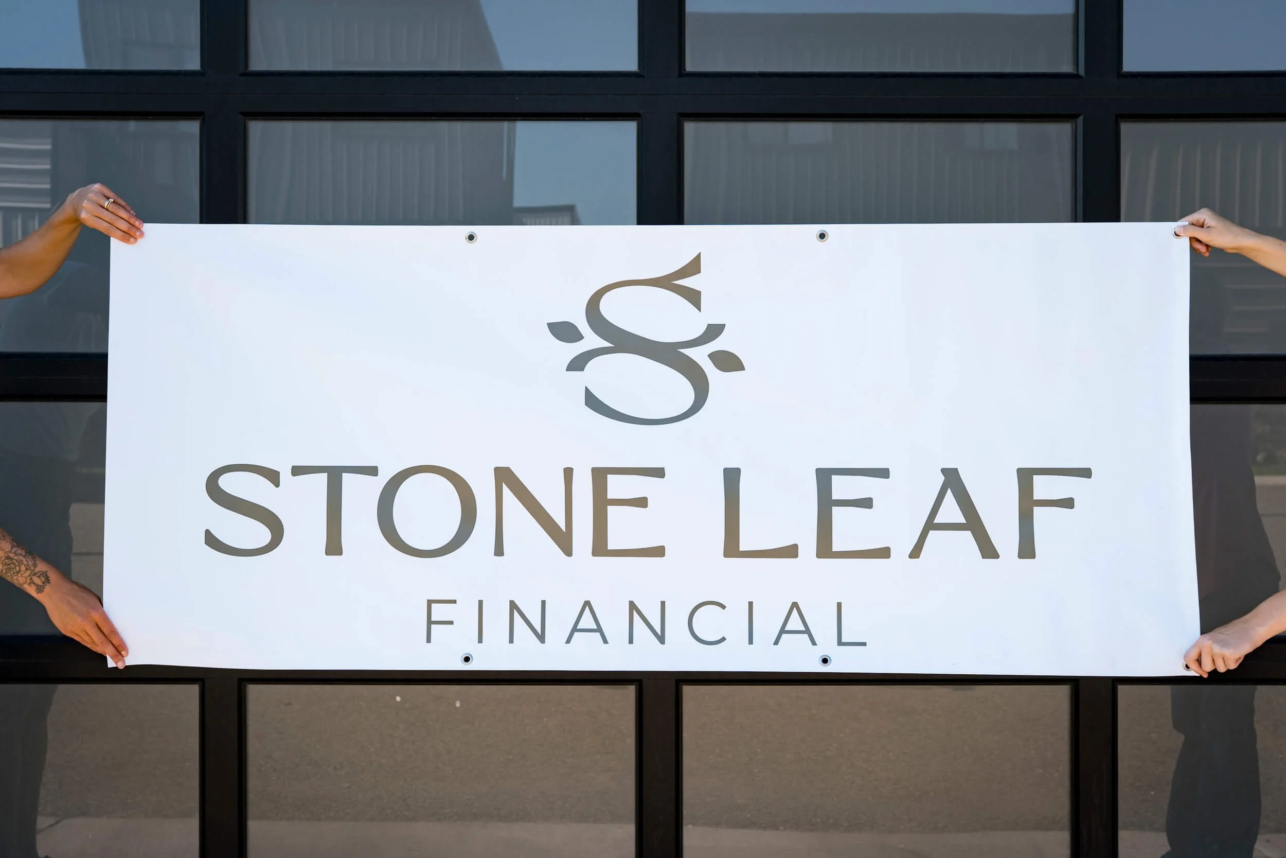 Large Stone Leaf Financial logo on a white vinyl banner with grommets