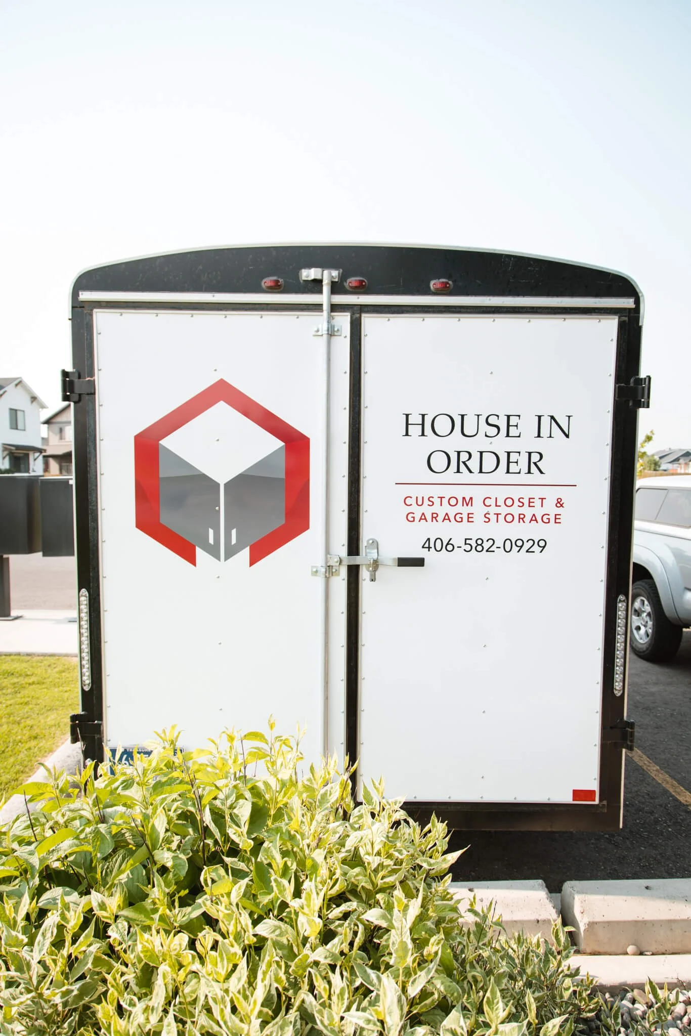 Minimalist trailer graphics for House in Order in Bozeman, Montana, with a red and black logo, clean typography, and contact information for custom storage services.