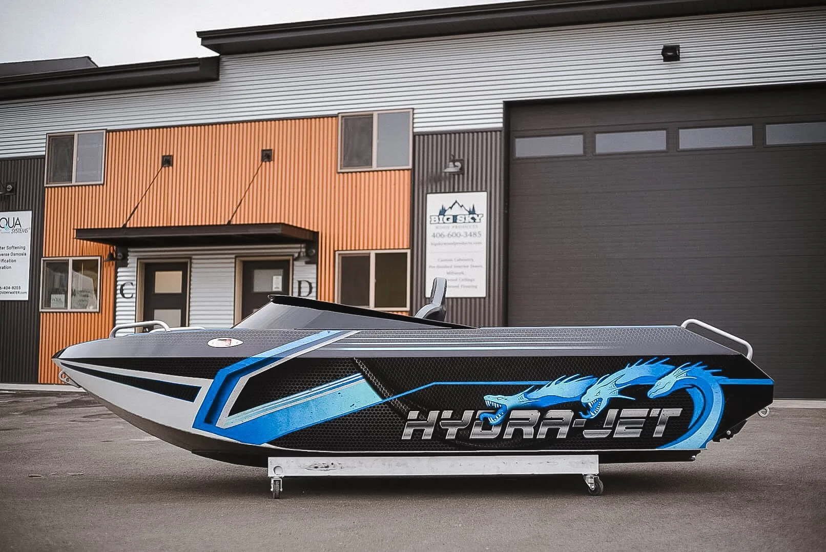 Small Hydra-Jet boat with bright blue, aqua and black Hydra vinyl wrap.