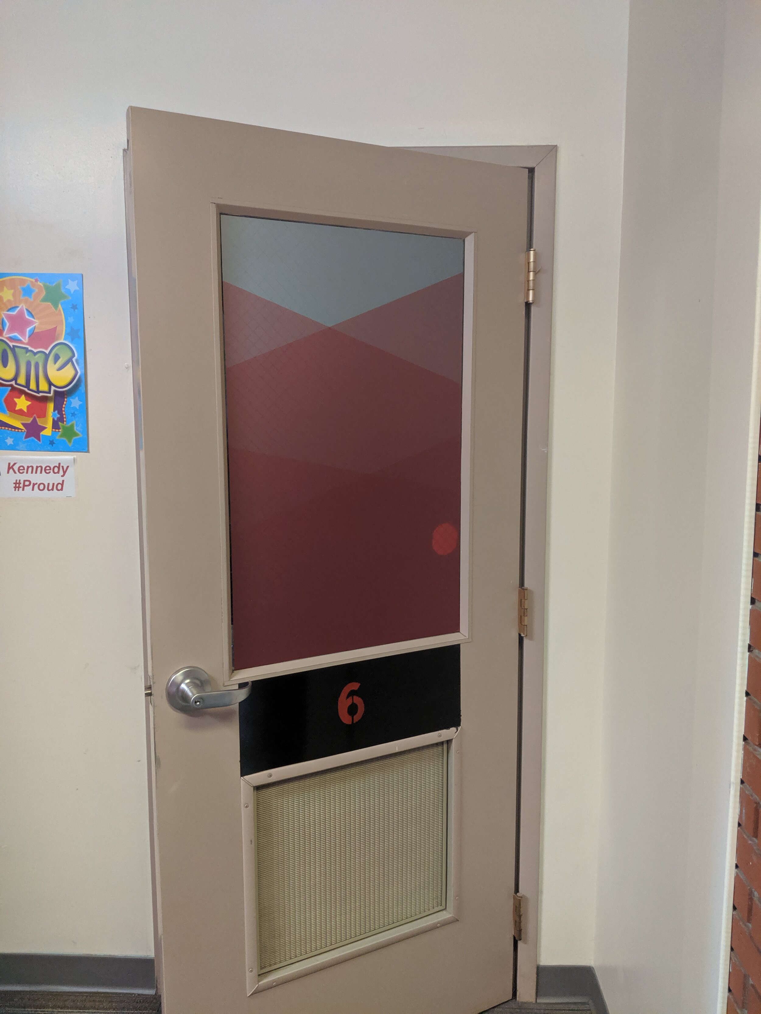Classroom door labeled with number 6 and partially open. Frosted privacy vinyl on window. In Butte, Montana.