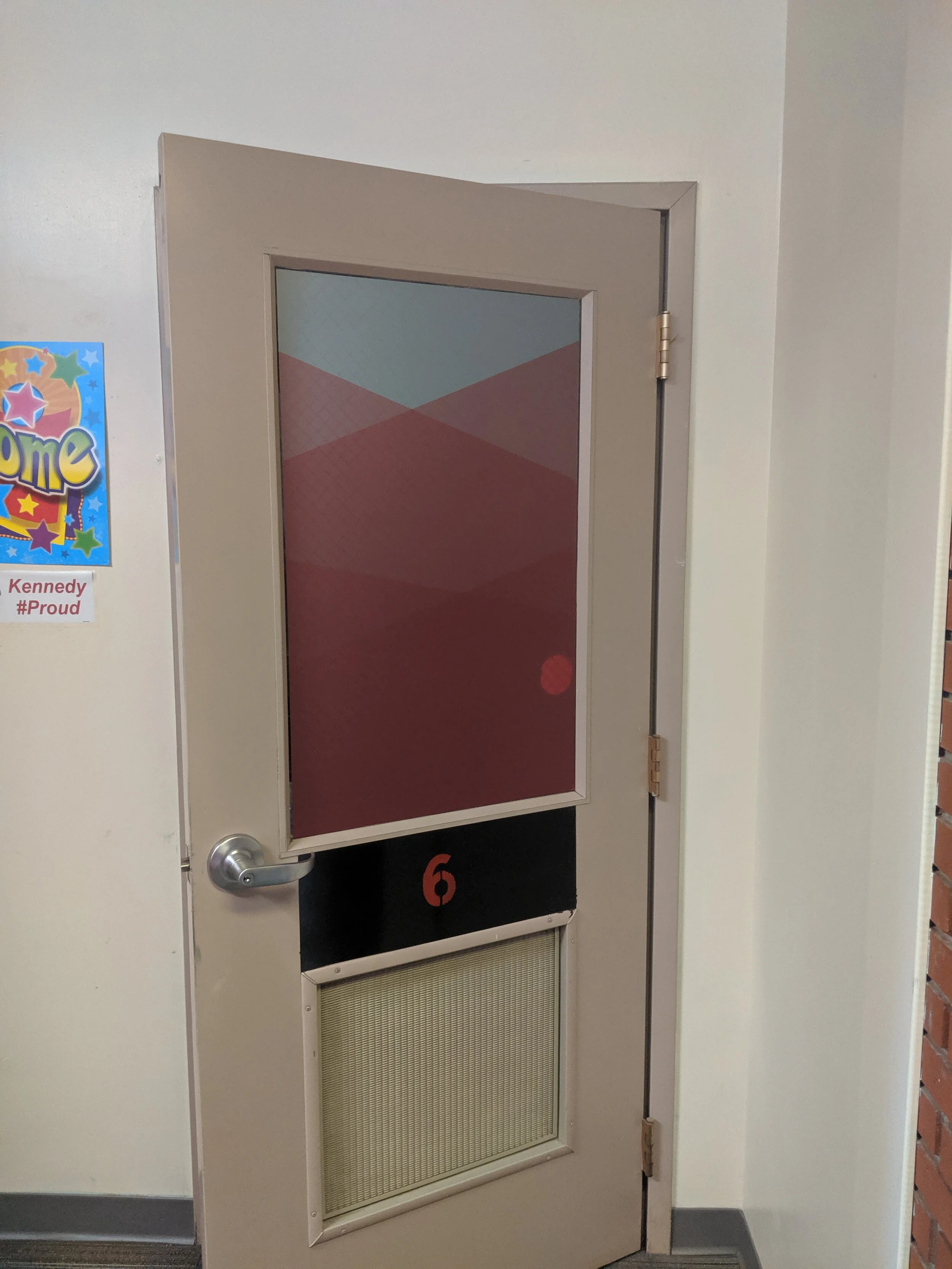 Classroom door labeled with number 6 and partially open. Frosted privacy vinyl on window. In Butte, Montana.