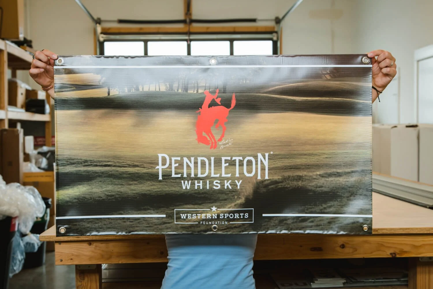 Person holding a Pendleton Whisky banner in a workshop in Bozeman, MT