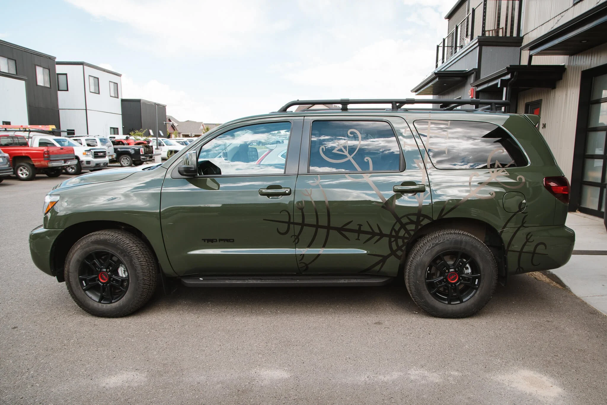 Vehicle wrap on a matte green Toyota Sequoia showcasing an abstract, Norse-inspired line design that creates a rugged, outdoor-ready aesthetic. Installed in Bozeman, Montana.