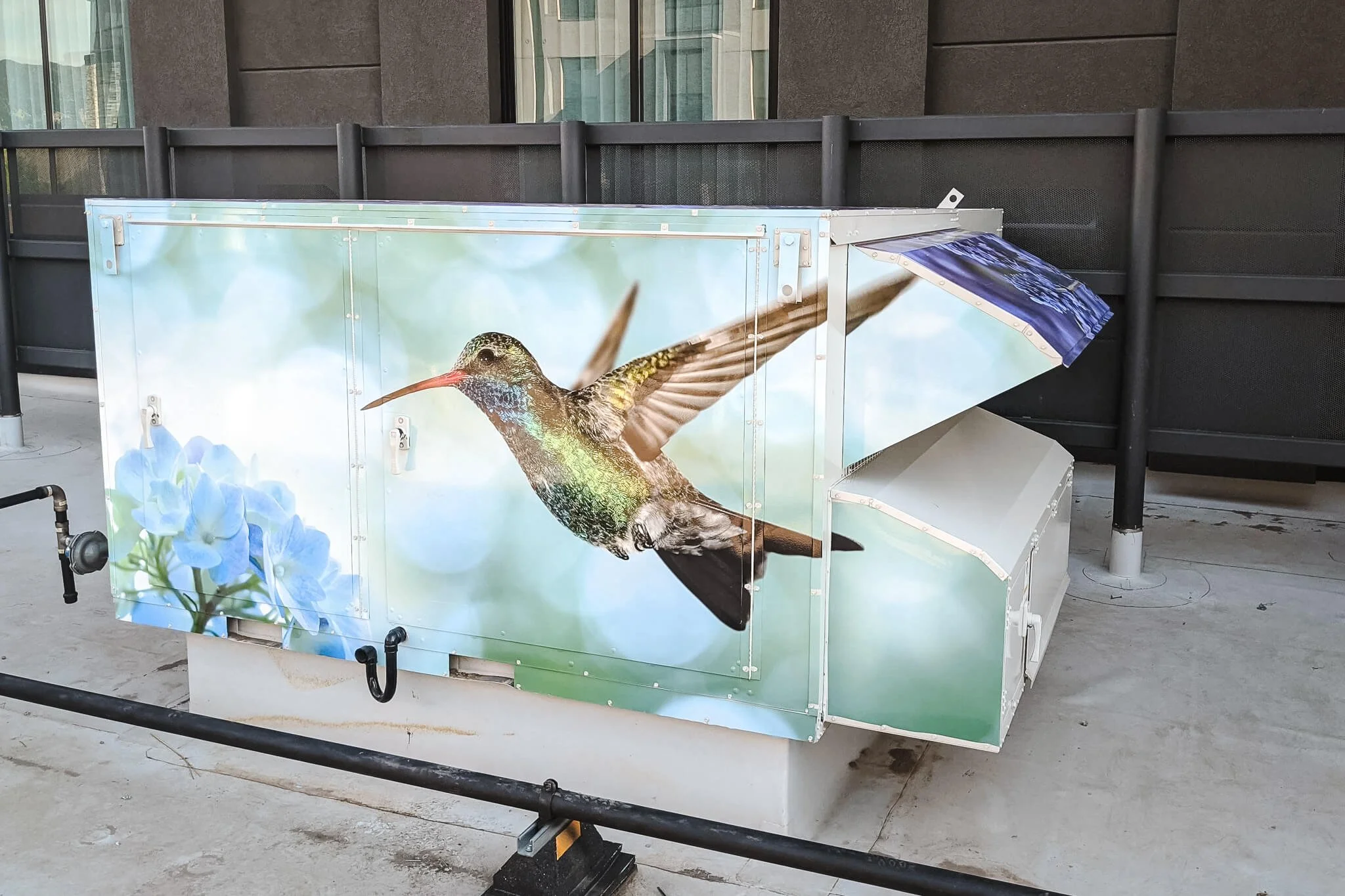 Rooftop air conditioning unit vinyl wrap with a photograph of a hummingbird with flowers