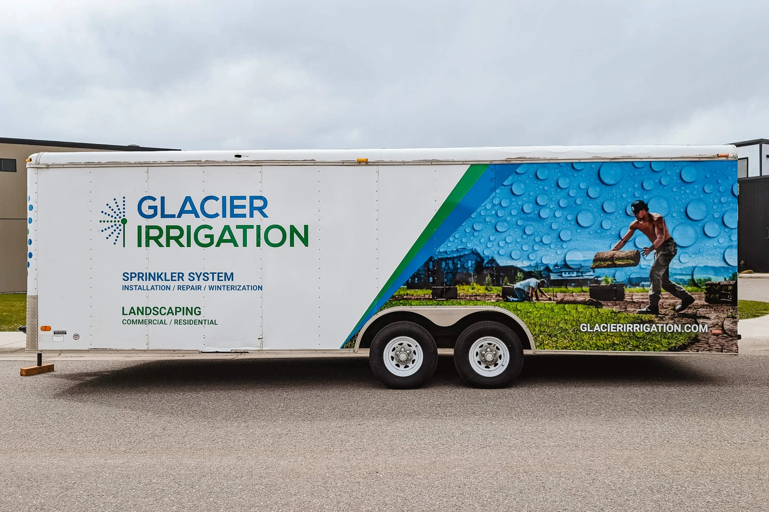 Large Glacier Irrigation vinyl logo at the front of a trailer with an angled partial wrap at the back. Large image of a man laying sod with water droplet texture overlaid