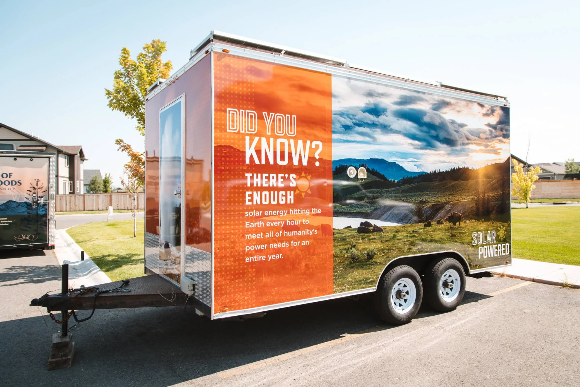 Full trailer wrap with a photograph of Yellowstone as the background with an orange overlay with white Did You Know? text on top