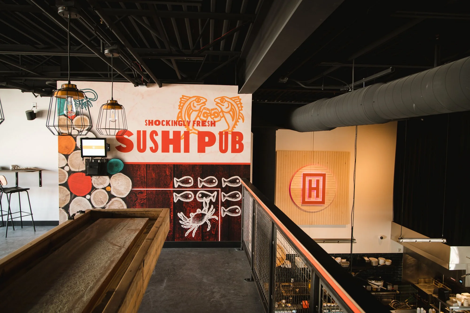 Wall wrap in the game area of Hachi Sushi Pub featuring illustrated fish and crabs. 