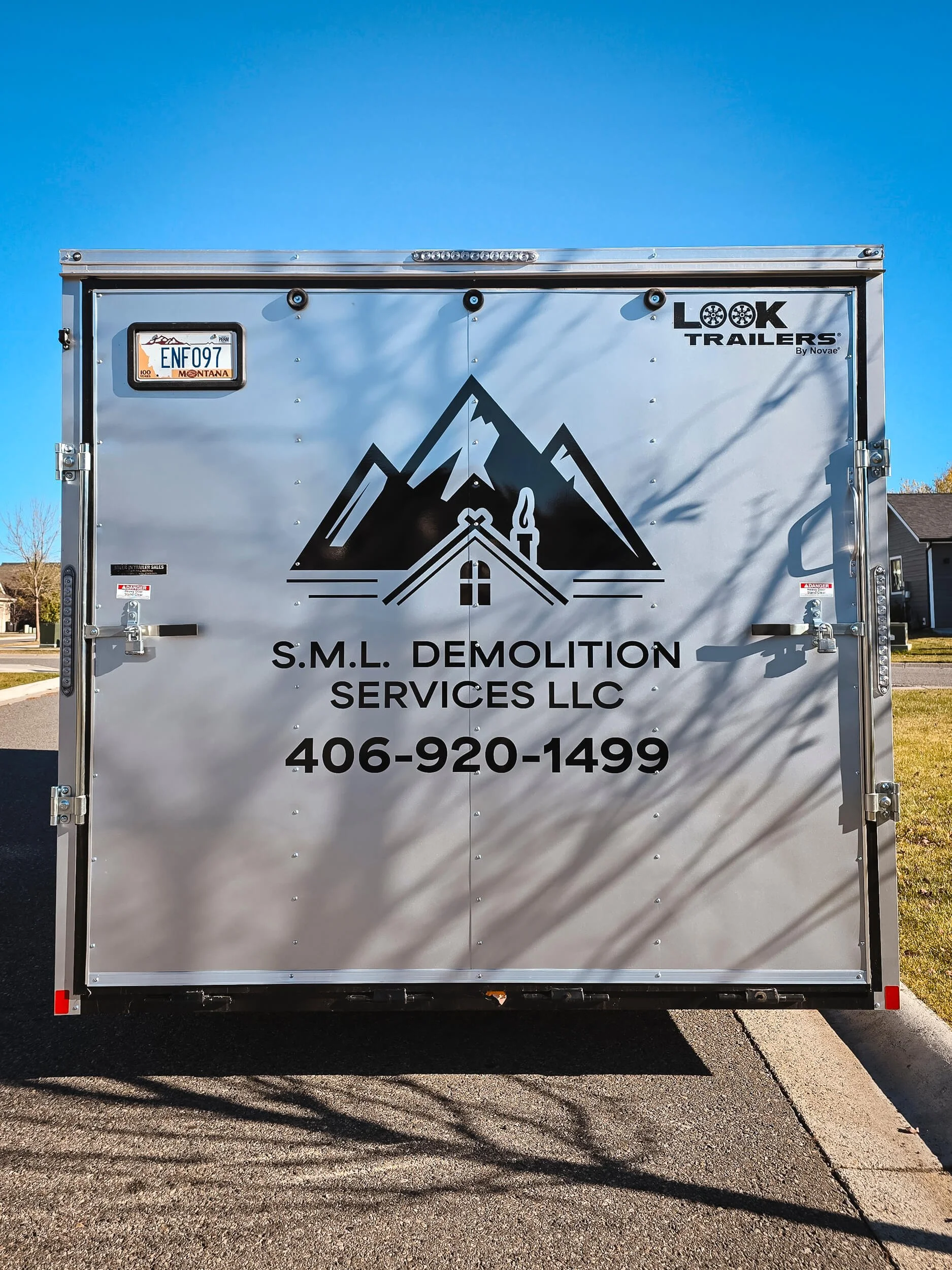 Black mountain and house vinyl graphic on the back of a trailer for SML Demolition Services