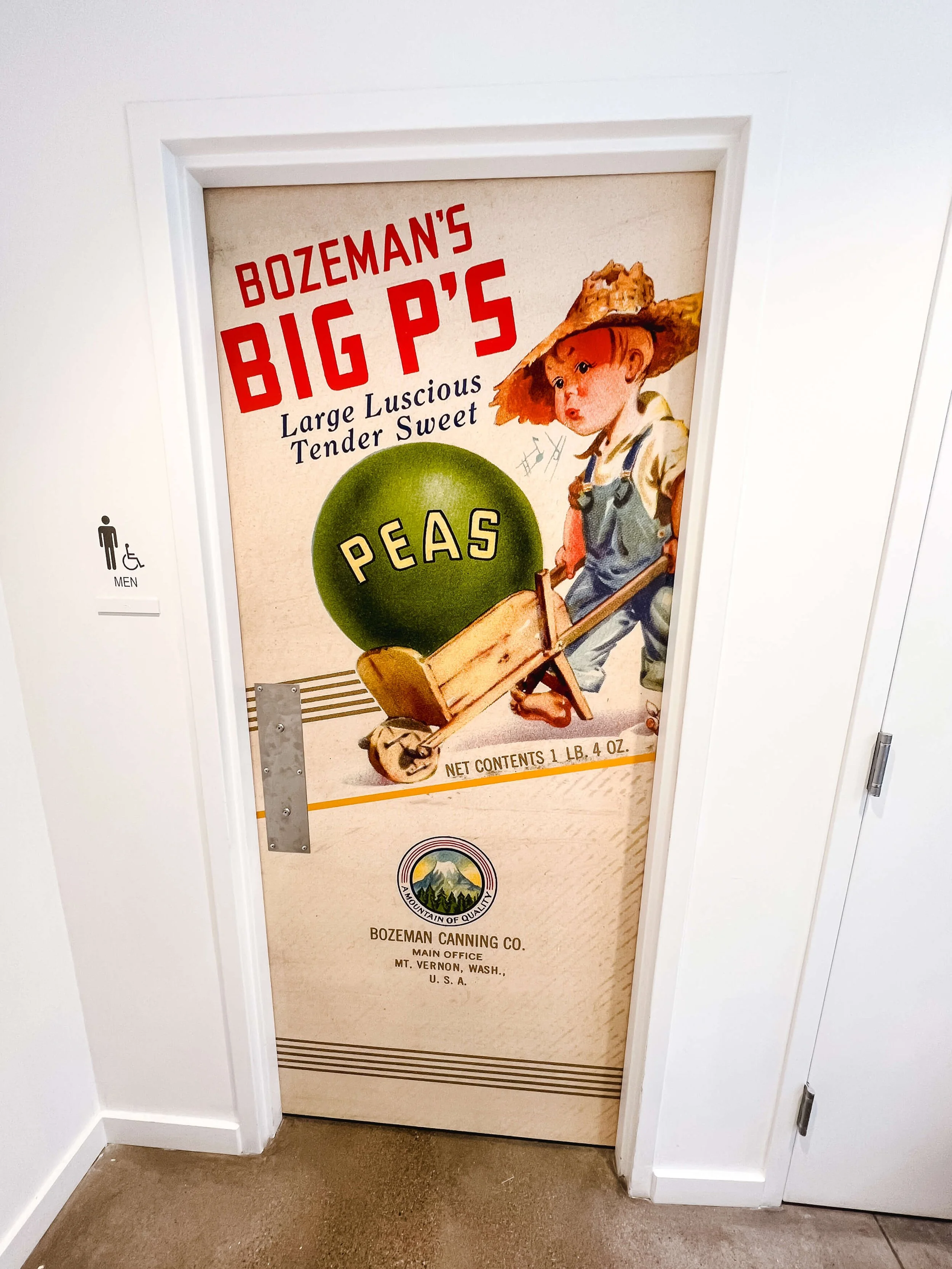 Custom vinyl wrap on a door displaying a nostalgic Bozeman canning label for peas, complete with colorful illustration and historic branding elements.