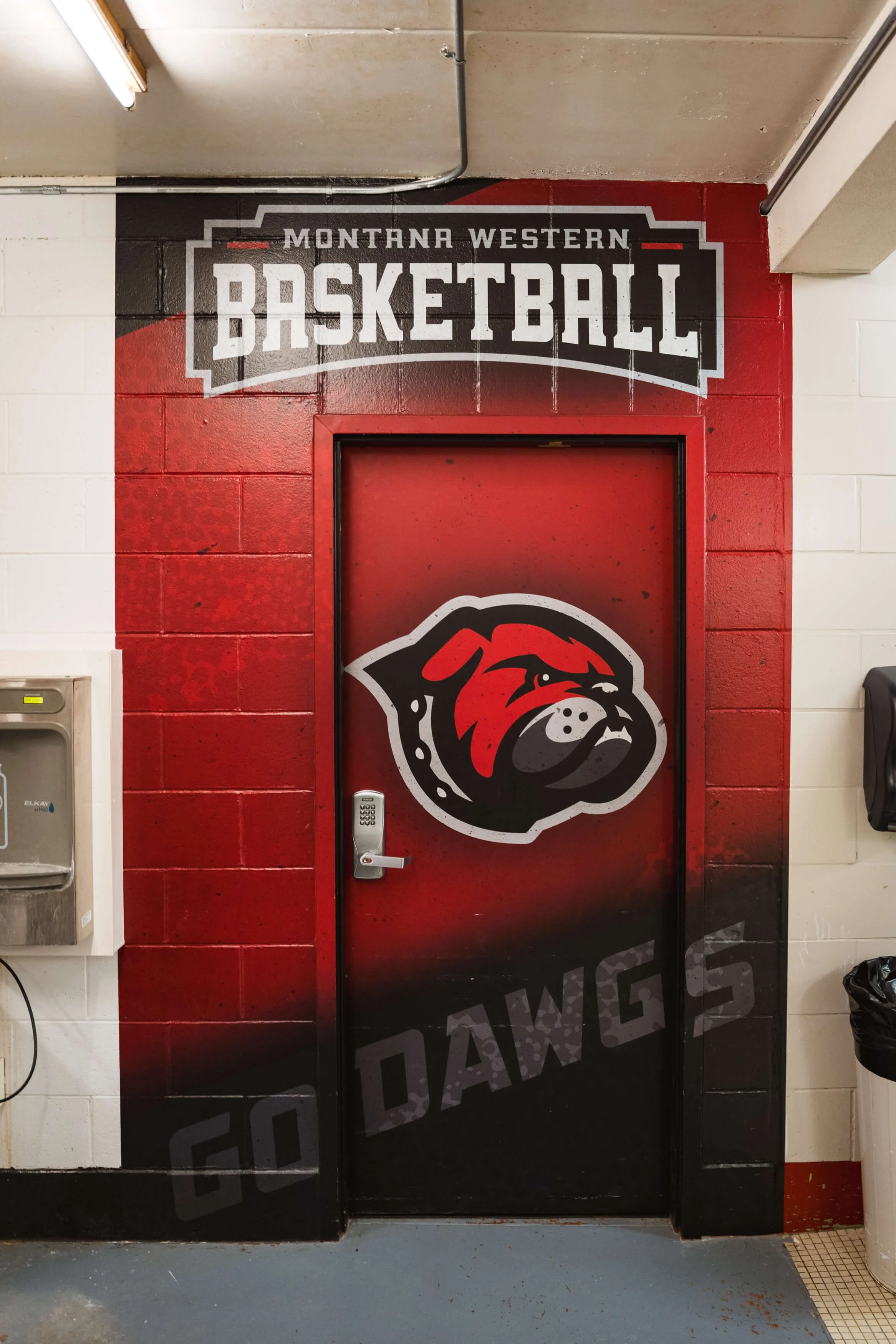 Door wall wrap with red gradient background and bulldog mascot beneath the “Montana Western Basketball” logo, adding a spirited entrance for the basketball program in Dillon, MT.