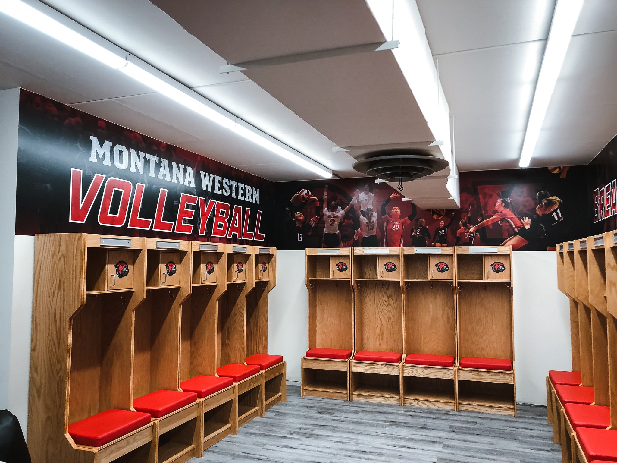 Montana Western volleyball locker room decorated with team images and branding.