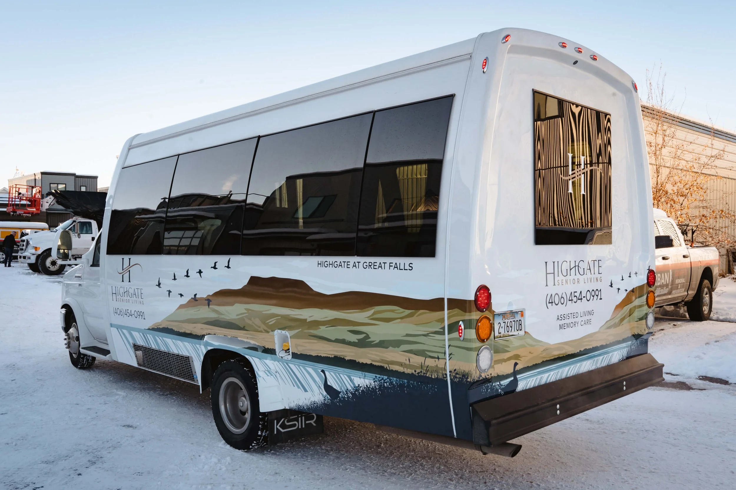 Passenger shuttle bus featuring a scenic mountain landscape vehicle wrap for Highgate Senior Living in Bozeman, MT.