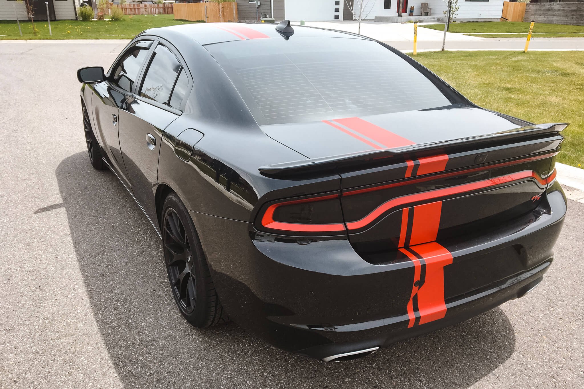 Dodge Charger wrapped with matte black paint and bright red racing stripes for a sporty and custom automotive vehicle wrap in Bozeman, Montana.