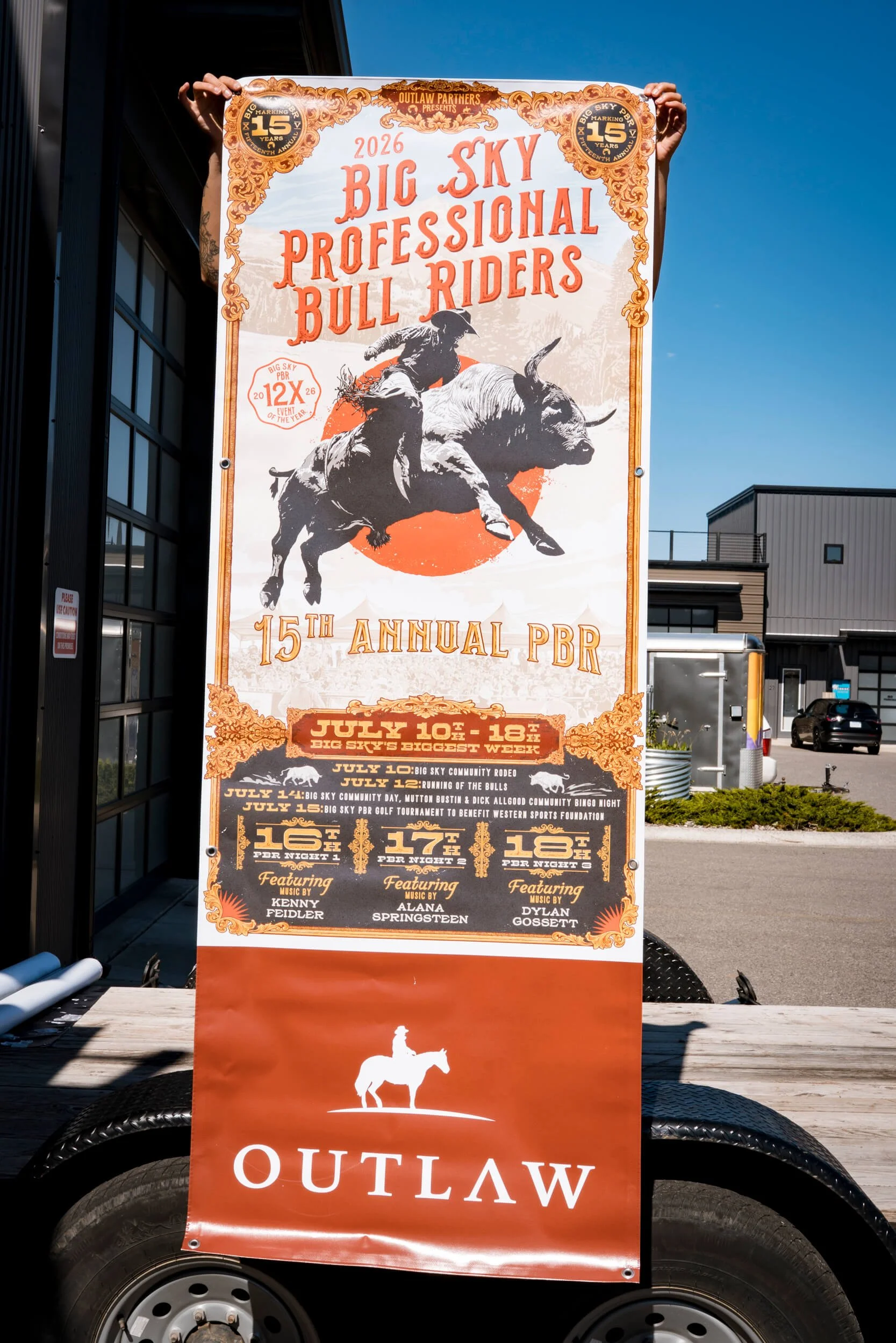 Long, skinny vertical banner with an illustration of a bull rider and western style scrolling promoting Big Sky Professional Bull Riders. Large Outlaw logo at the bottom of the banner