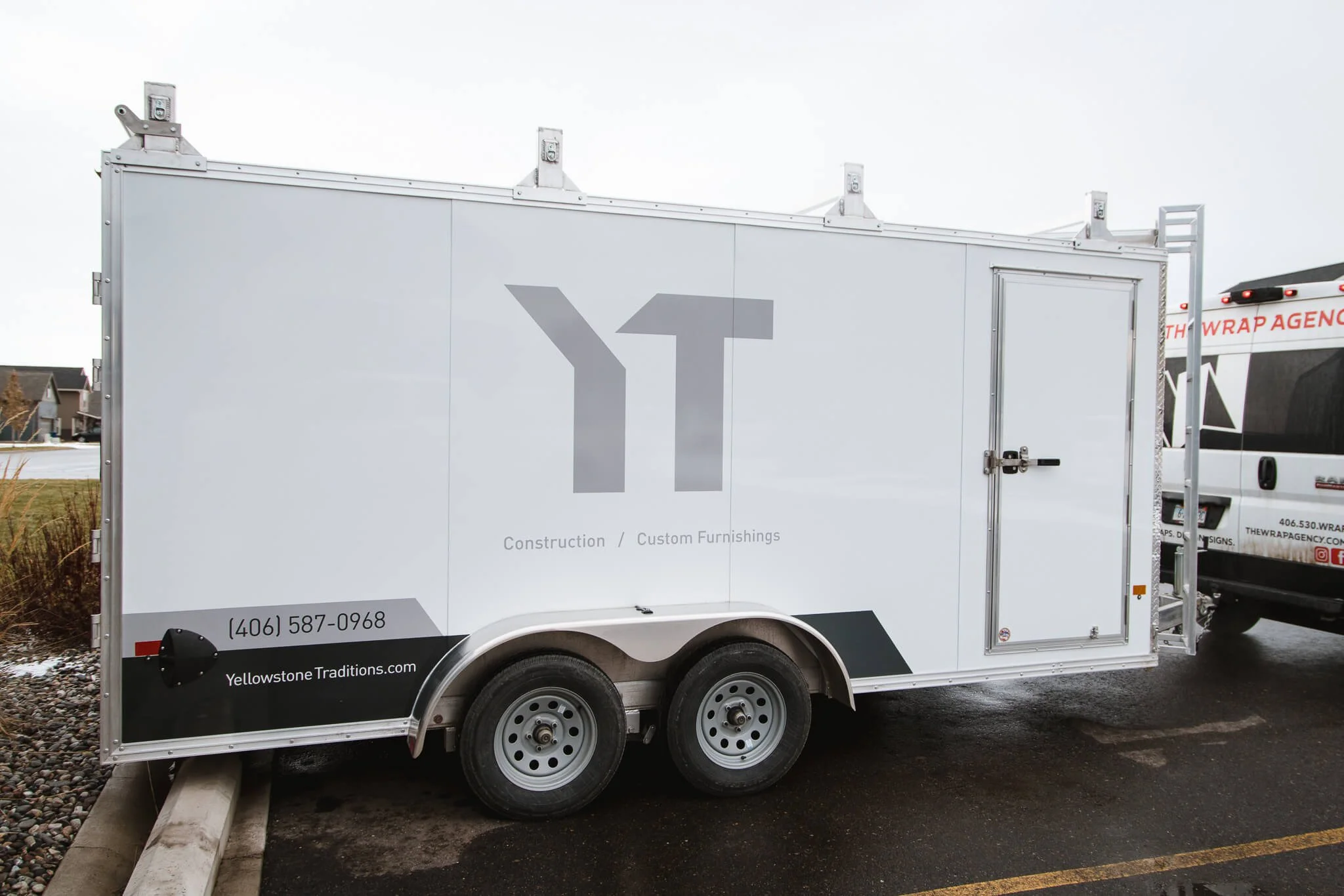 Trailer graphics for Yellowstone Traditions in Bozeman, Montana, with clean modern design featuring the YT logo in gray on a white background, paired with contact details and web address.