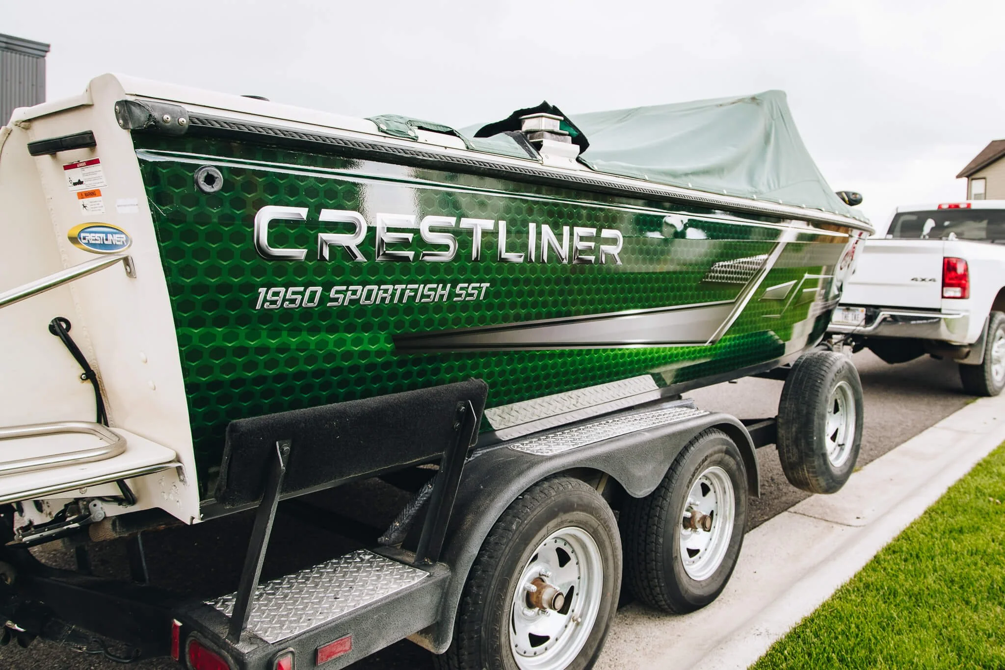 Crestliner 1850 Sportfish SST with a green and black custom vinyl wrap featuring sleek gradient detailing and branding.