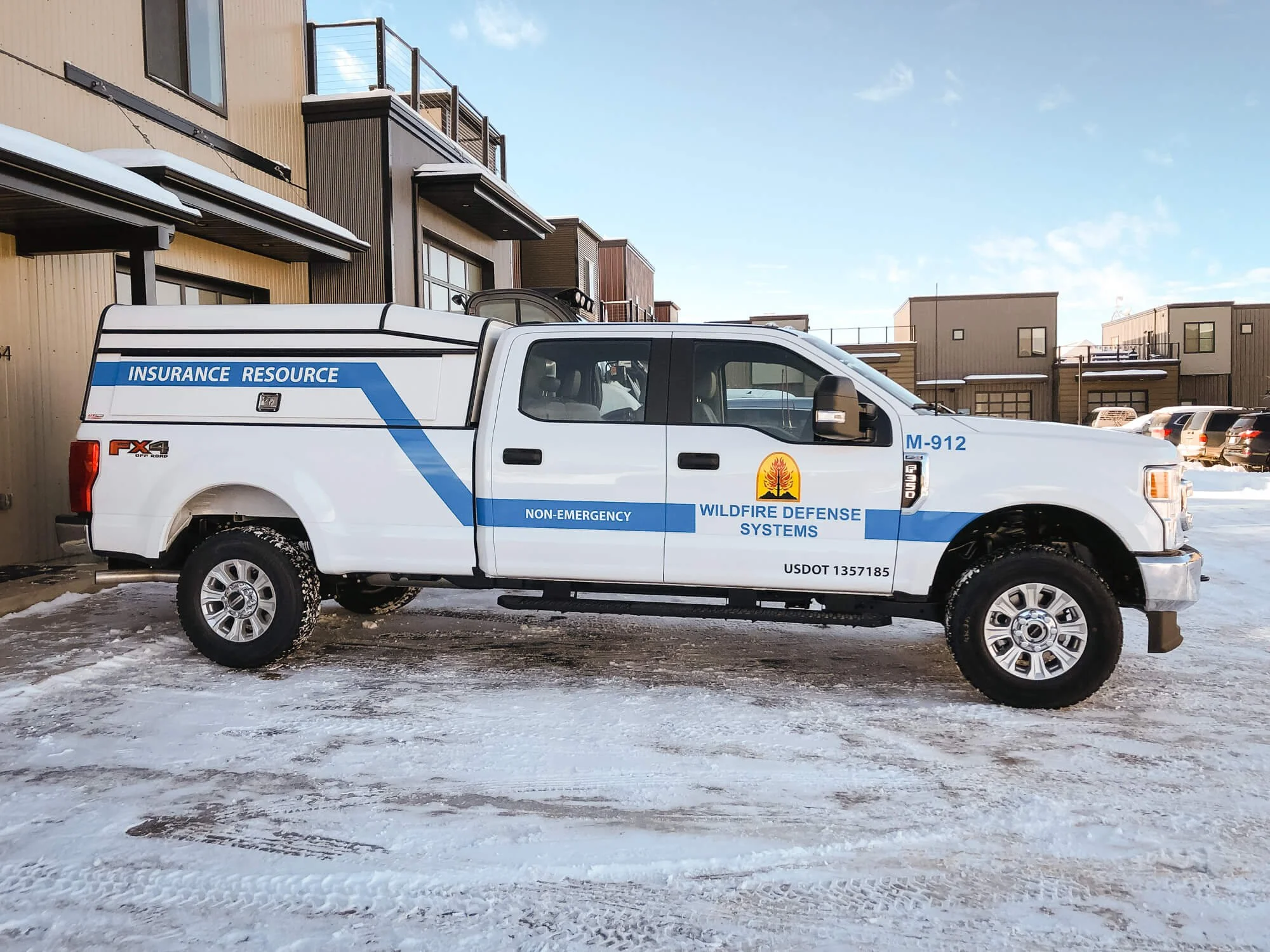 Branded fleet wrap on a white pickup truck for Wildfire Defense Systems featuring crisp blue striping, “Insurance Resource” and “Non-Emergency” text, and official logo application for professional field visibility. Location: Bozeman, Montana.