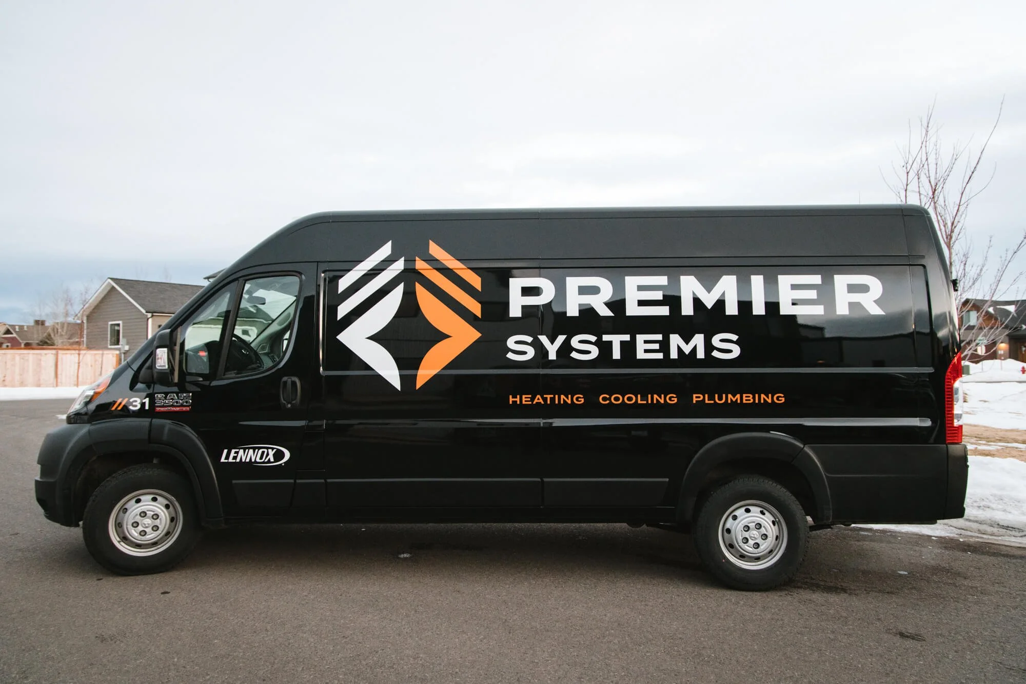 Premier Systems cargo van with large-scale logo, black and orange accents, and clear HVAC service messaging—a sleek and bold full-coverage vehicle wrap in Bozeman, Montana.