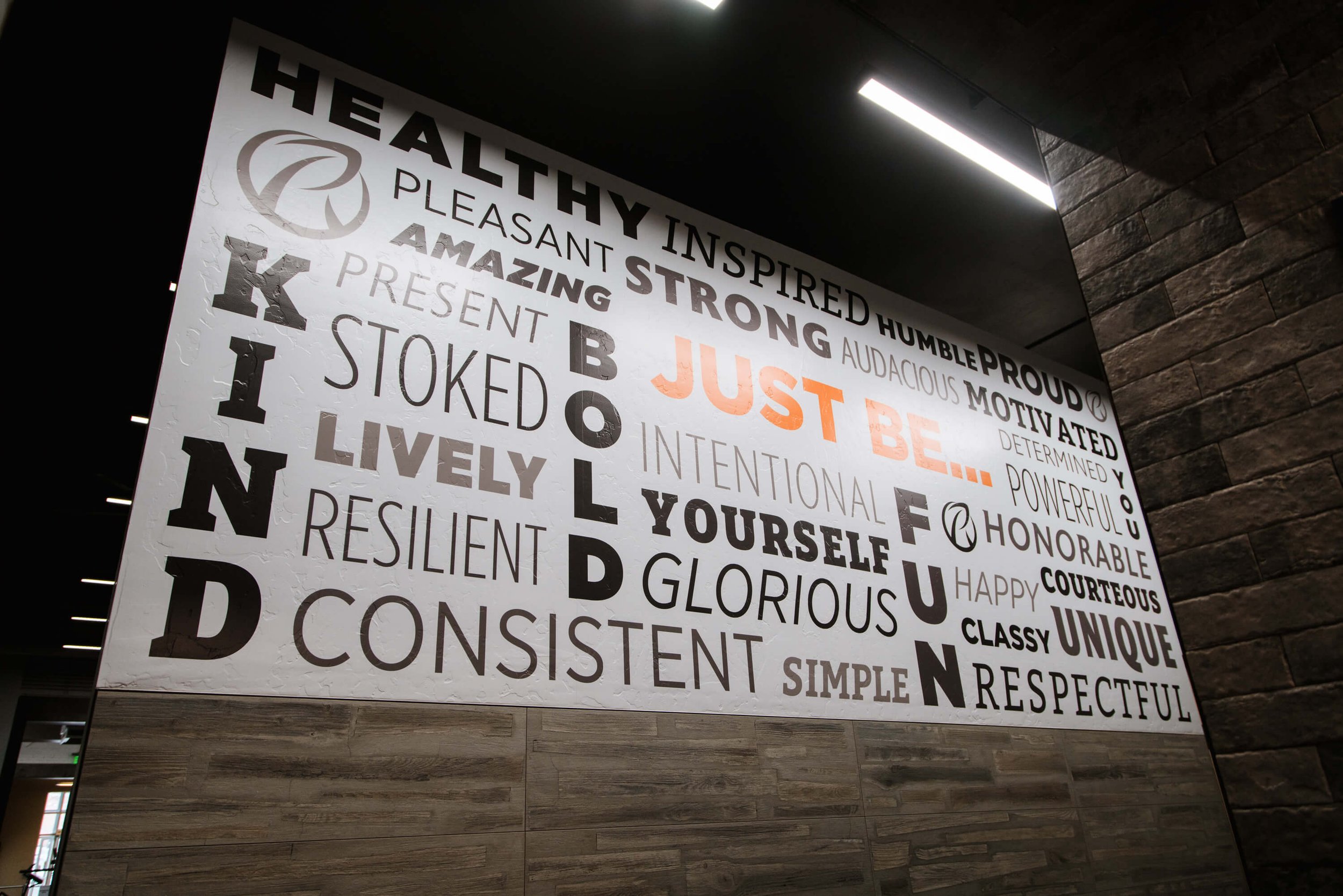 Typography-driven motivational wall wrap featuring words like “KIND,” “BOLD,” and “GLORIOUS” in multiple fonts and colors in a gym setting. Installed by The Wrap Agency at Ridge Athletic Club.