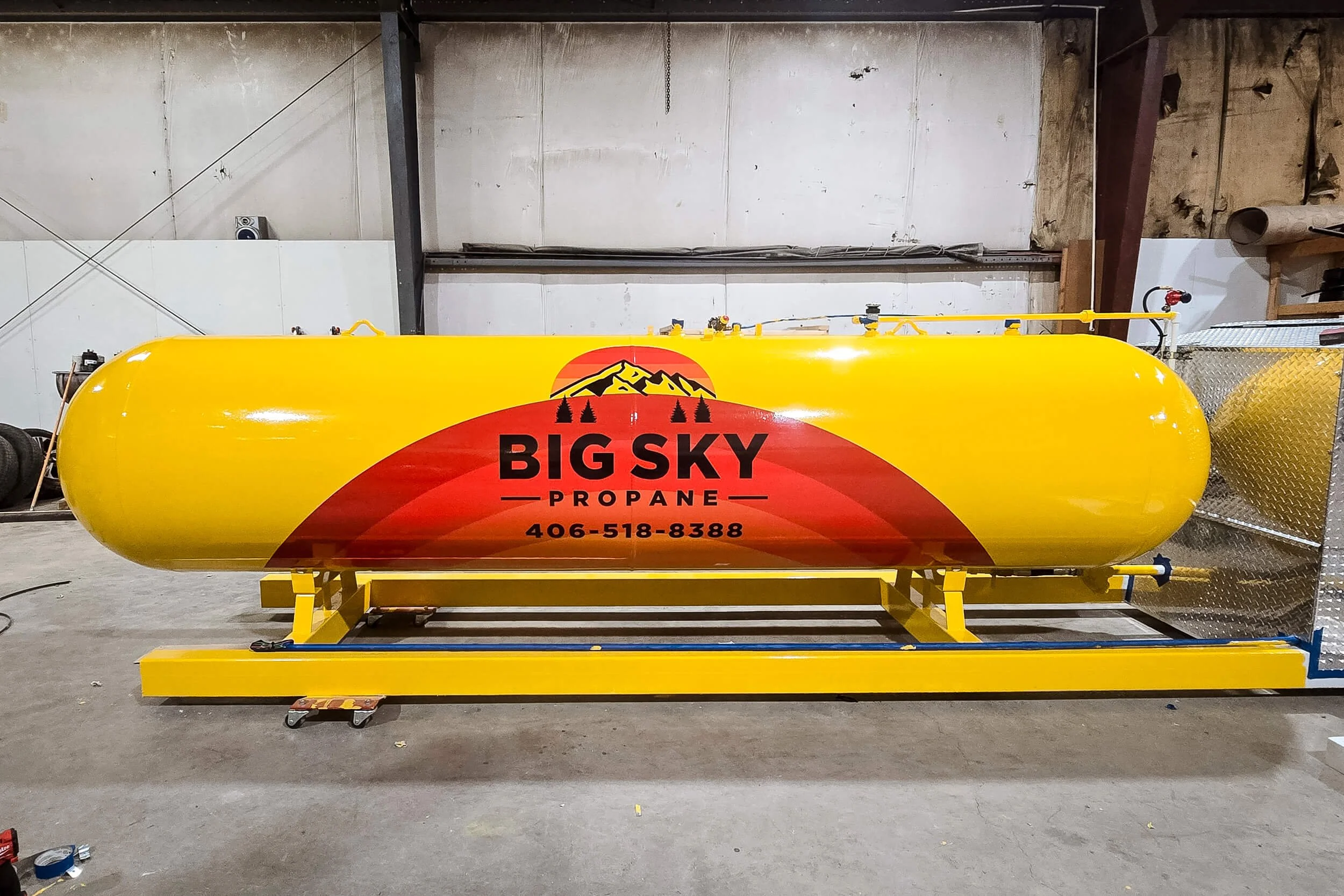 Small propane tank with Big Sky Propane logo with multi-colored arch