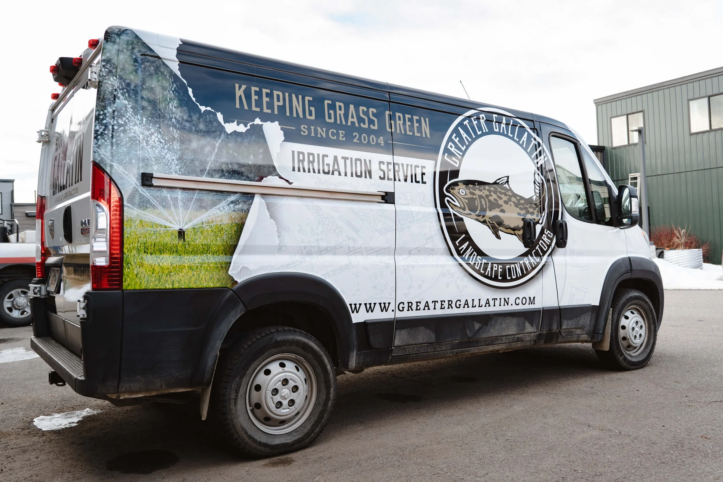ProMaster van with large Greater Gallatin Landscape Contractors logo towards with front with a torn paper effect revealing a sprinkler photo beneath