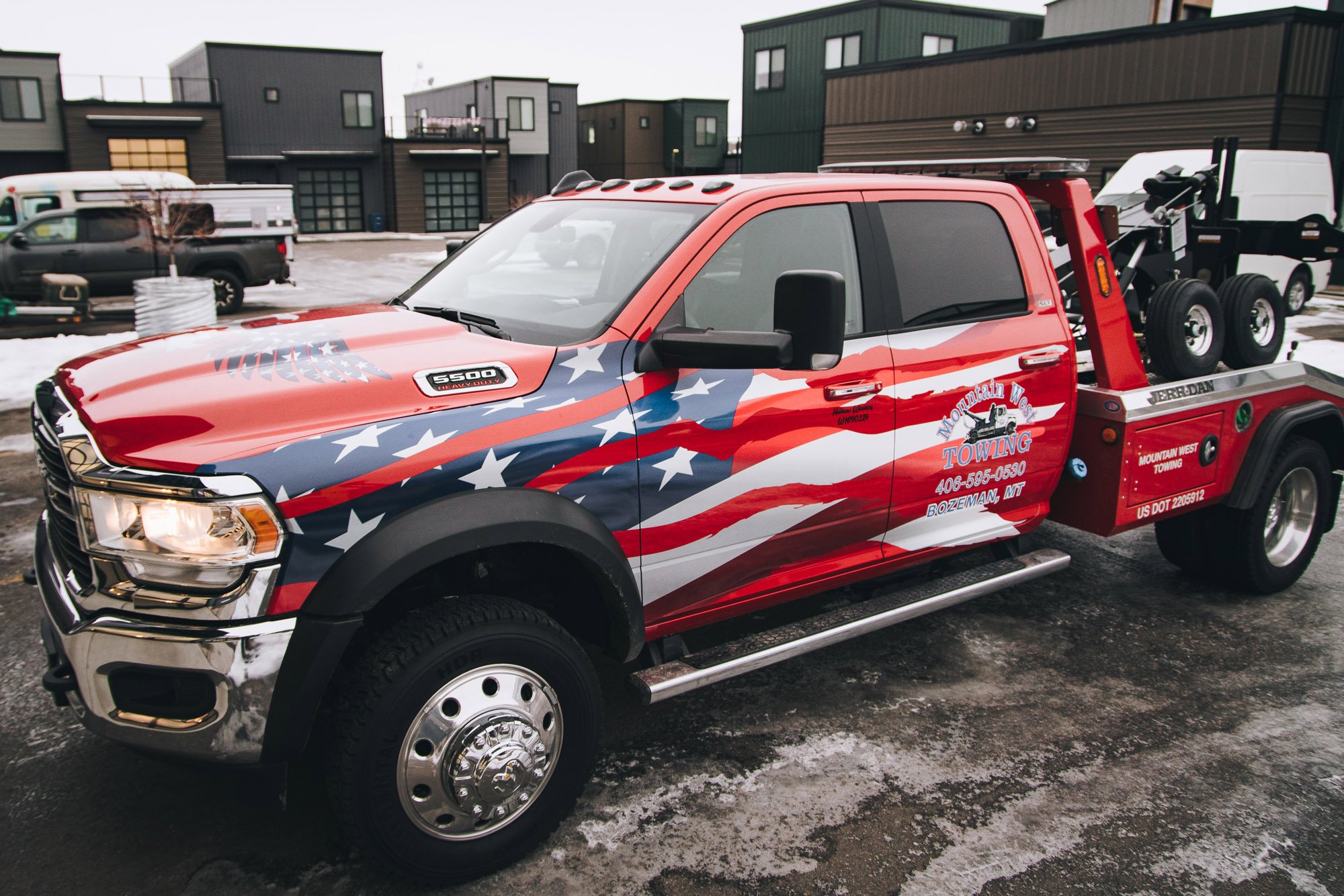 Mountain West Towing Ram 5500 with full American flag wrap and custom logo graphics, highlighting patriotic vehicle wraps for towing fleets in Bozeman, Montana.