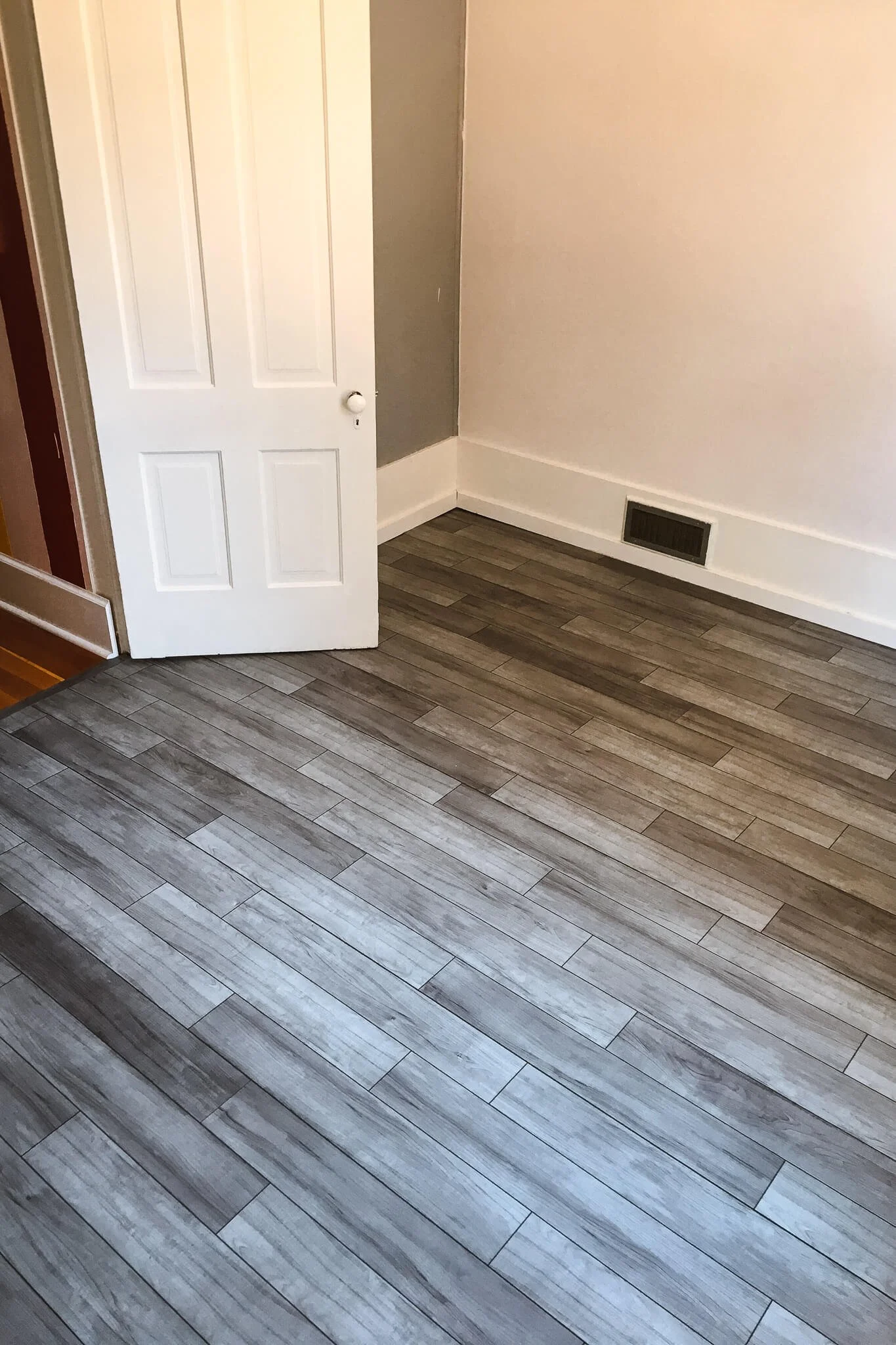 Another view of a room featuring high-quality custom vinyl wraps on the floor to mimic gray-stained hardwood, perfect for modern interior upgrades.