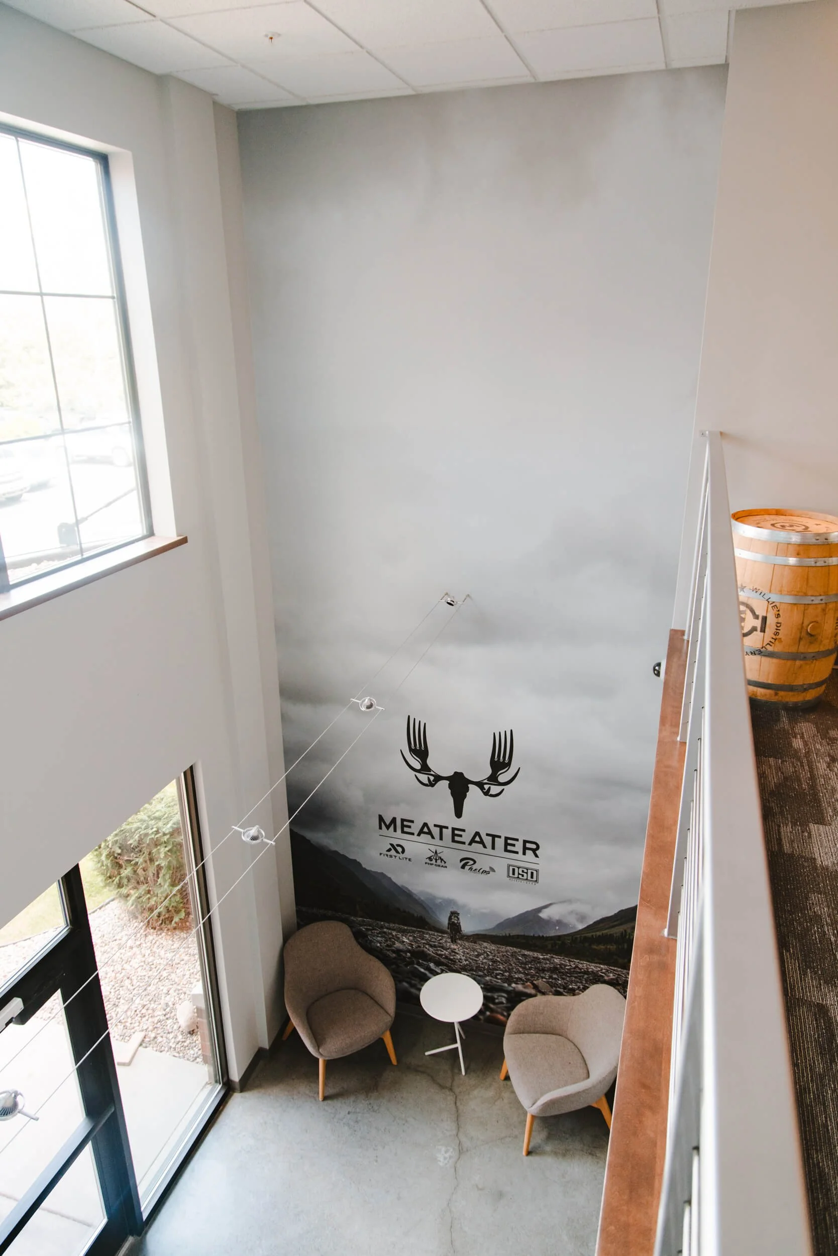 Branded lobby wall wrap with large logo on scenic background by Wrap Agency for Meateater in Bozeman, MT.