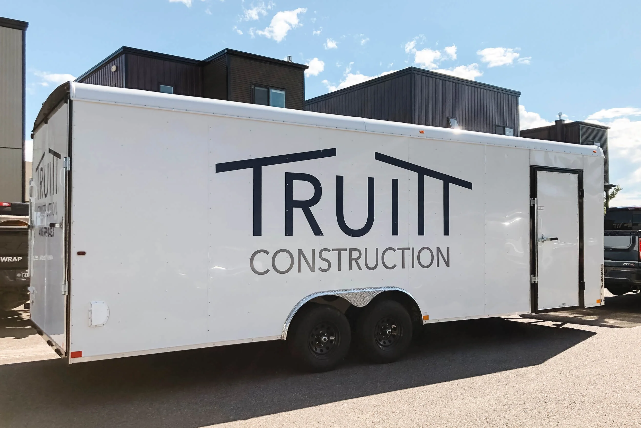 White trailer with large navy blue and grey vinyl logo in Bozeman, Montana