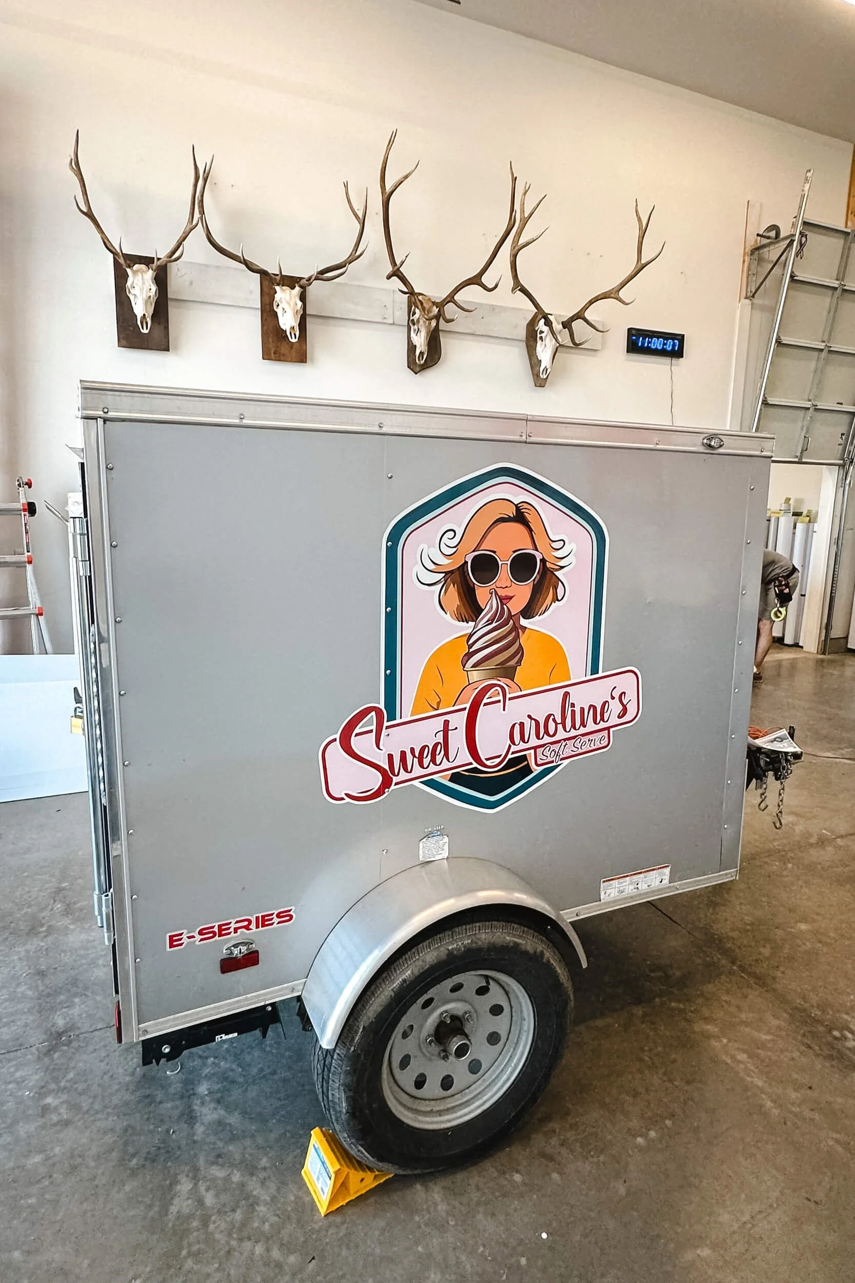Cute illustrated logo of a woman eating ice cream as a vinyl graphic on a tiny trailer