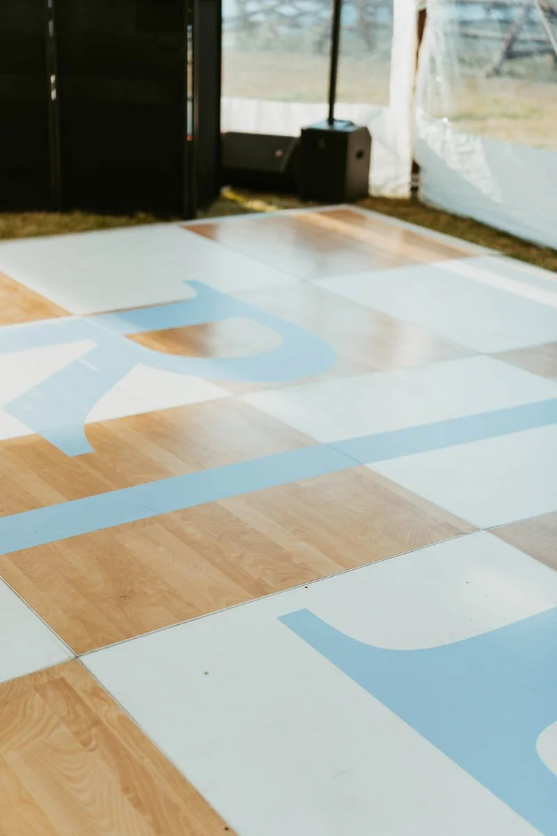 Monogram spot graphic of custom initials on wedding dance floor wrap at 320 Guest Ranch in Gallatin Gateway, MT. Designed for Golden Hour Events and photographed by Danielle Mullens Photography.