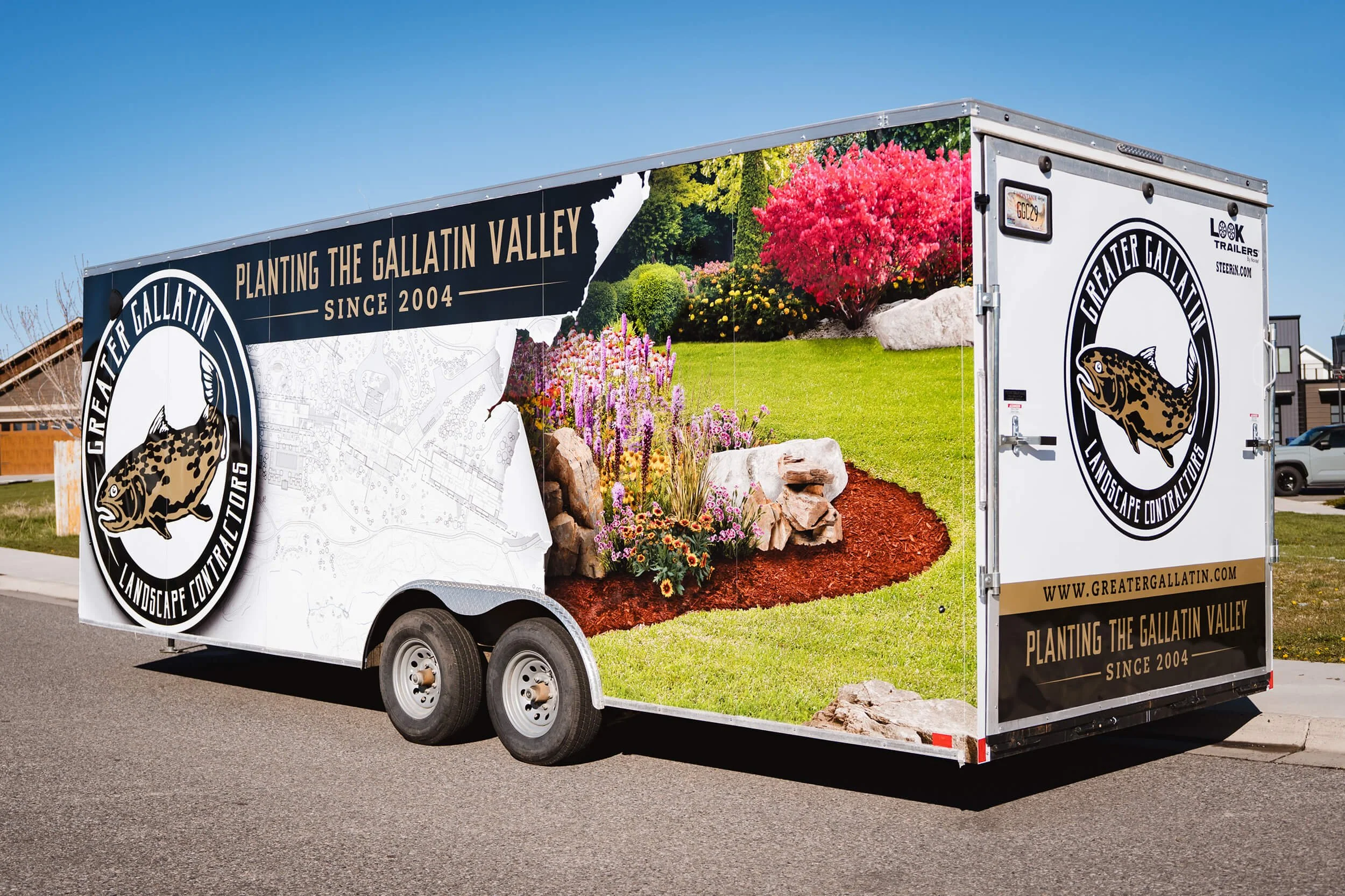 Trailer wrap for Greater Gallatin Landscape Contractors in Bozeman, MT, featuring high-definition lawn and garden scene with torn blueprint effect and circular fish logo. 
