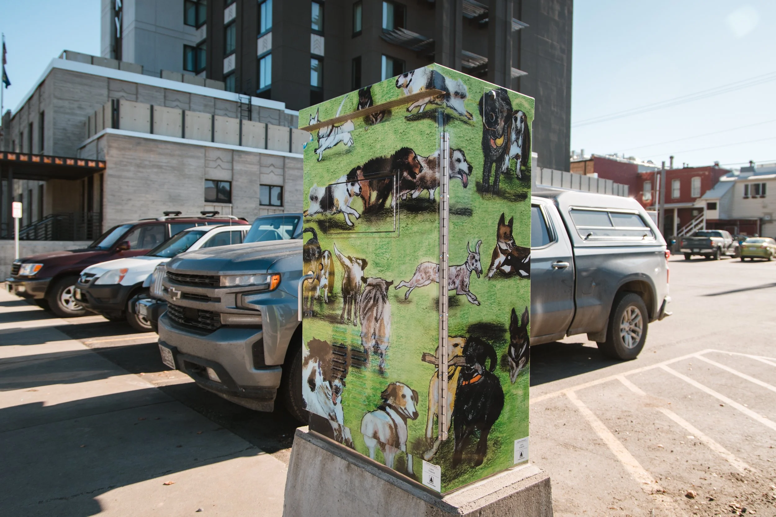 Bright green vinyl wrap traffic box on a busy downtown street with a wrap promoting nature and dogs.